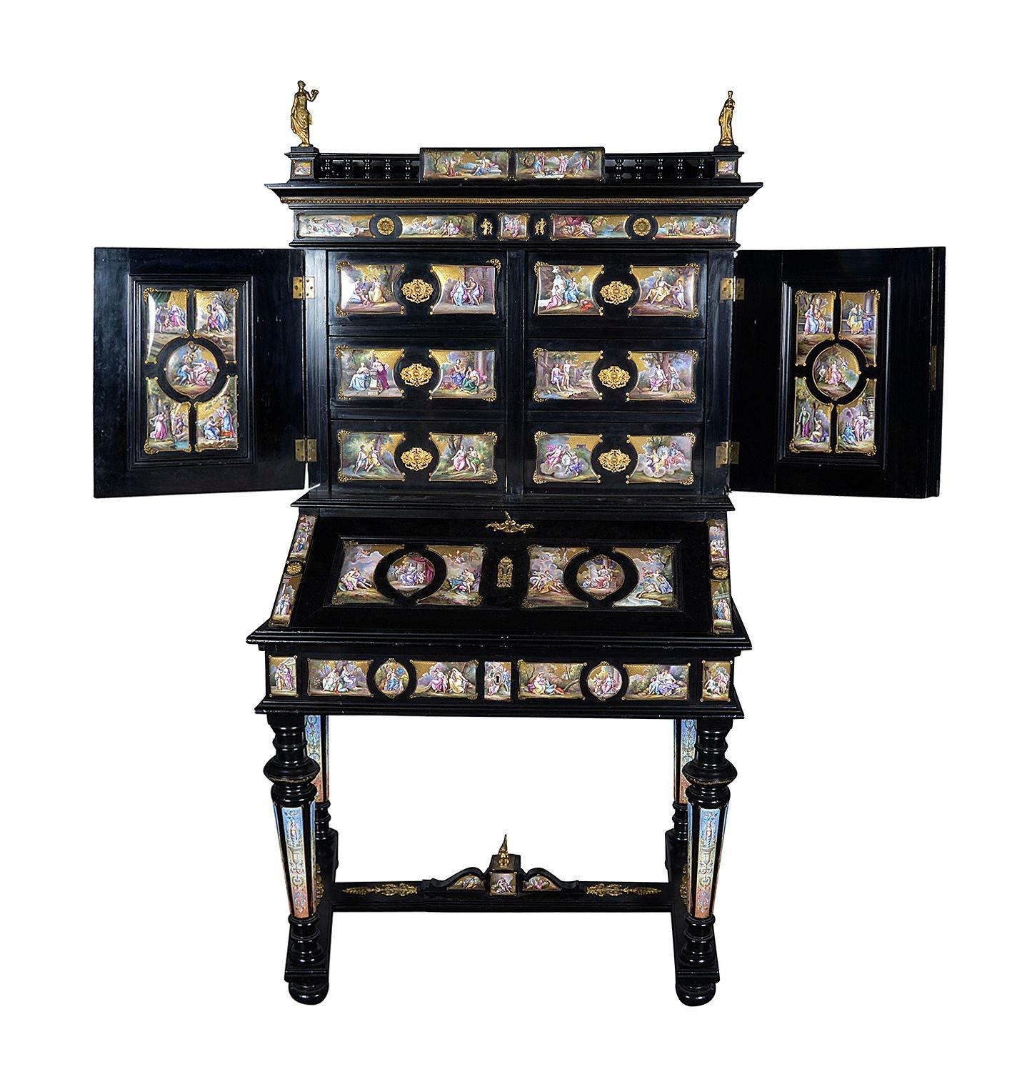 A fine quality Viennese late 19th century, gilt-bronze and enamel mounted ebonised bureau-cabinet

decorated all-over with shaped enamel plaques depicting mythological scenes, interspersed by pierced enamelled gilt-metal mounts, surmounted by a