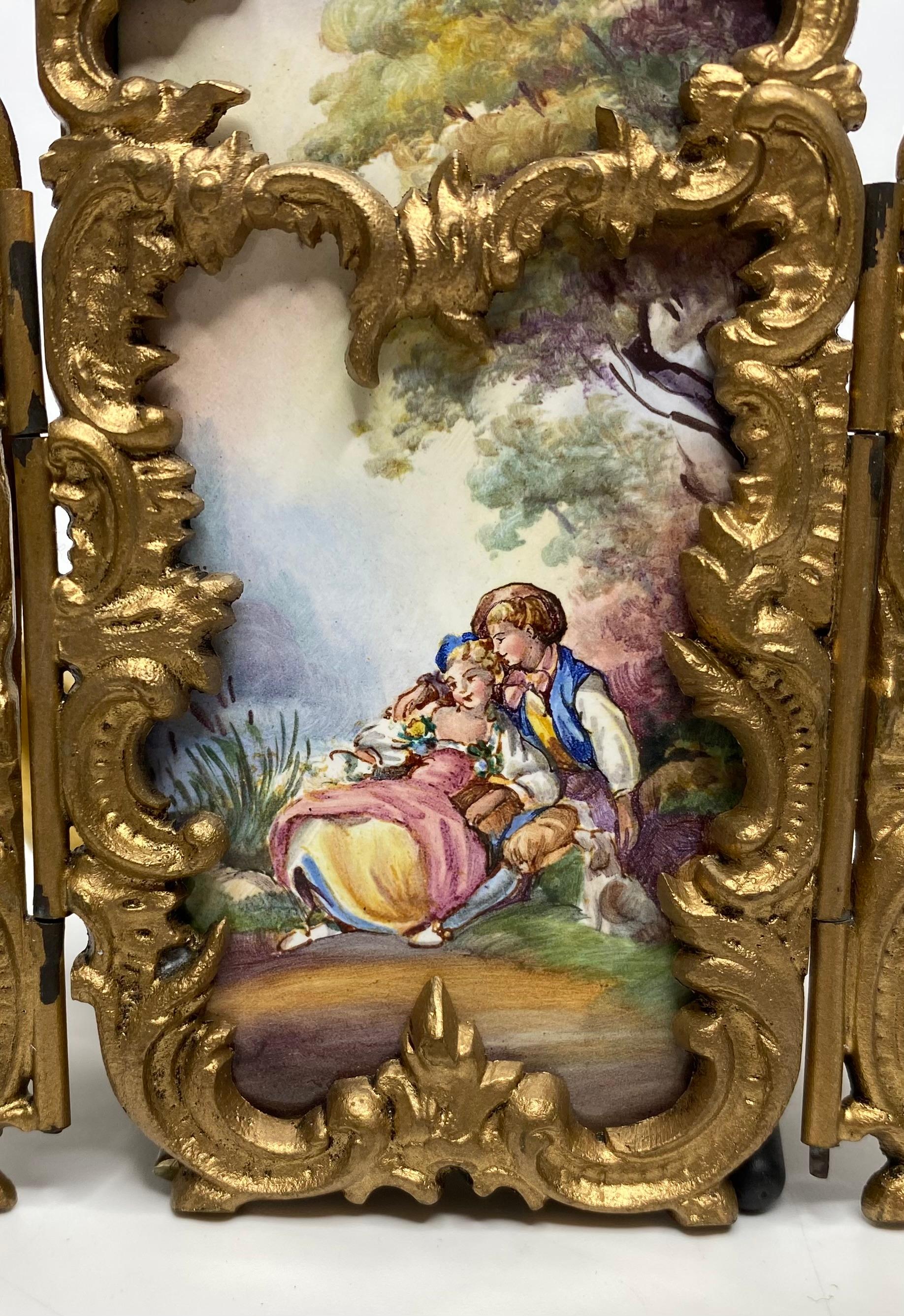 Viennese enamel miniature screen, Austria, c. 1900. Hand painted with panels after Francois Boucher, of courting couples wearing 18th Century costume, and sat in idyllic rural settings.
The panels mounted in hinged elaborate gilt metal rococo scroll