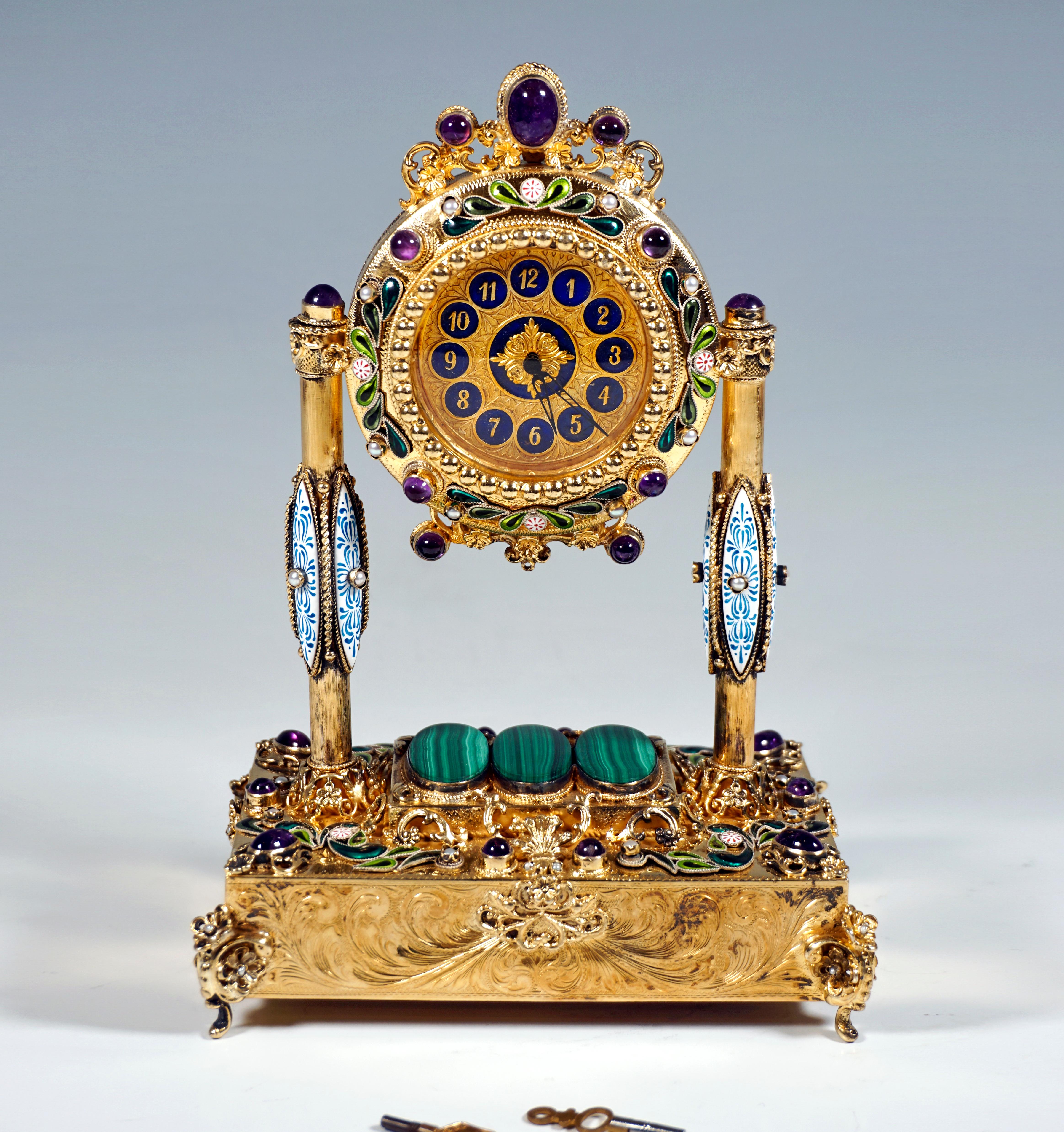 Artfully decorated silver gilded table clock by a Viennese master:
Flat, rectangular corpus containing the musical mechanism, standing on four elaborately decorated volute feet attached to the corners, rectangular elevation in the middle at the