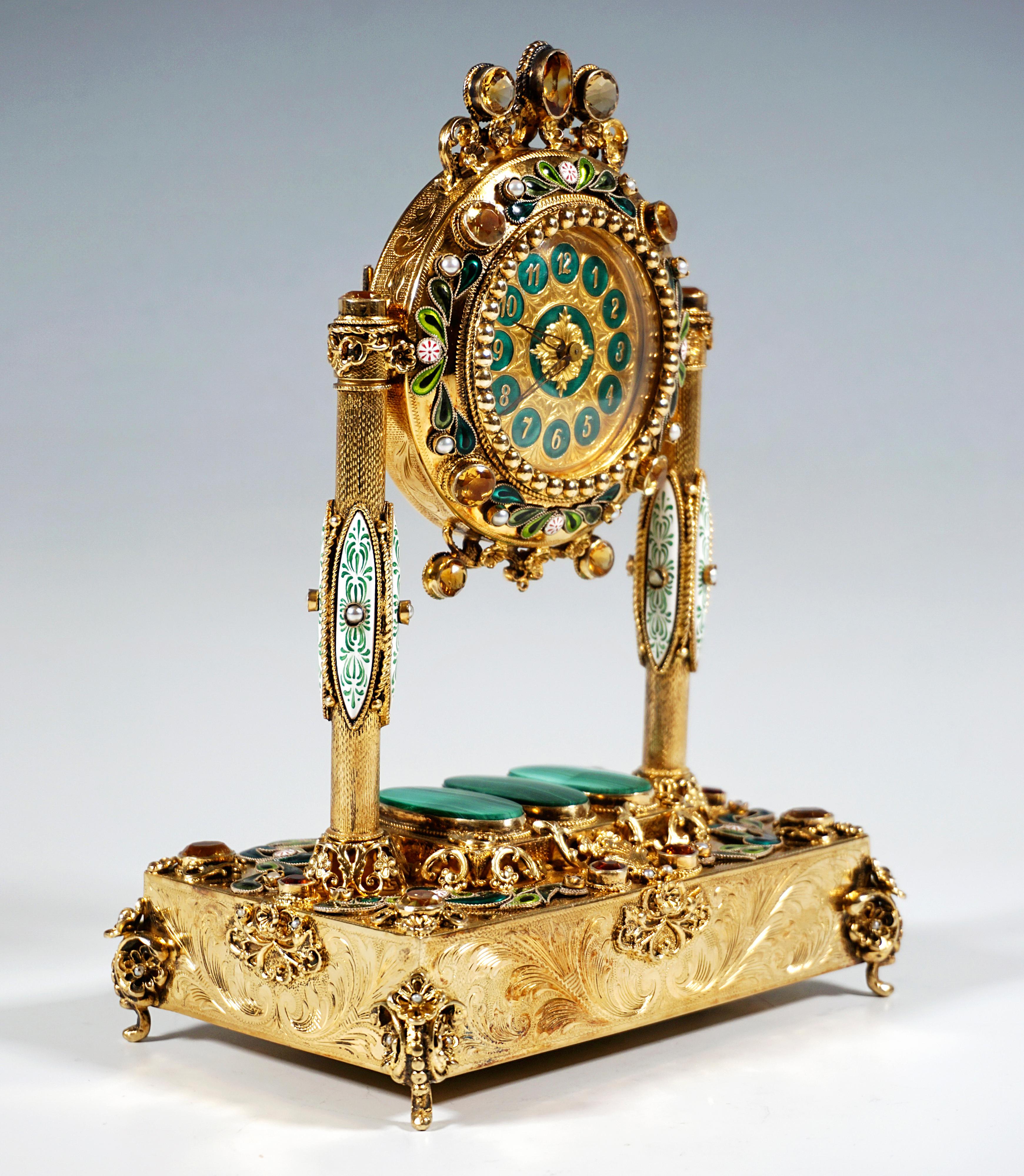 Reloj de sobremesa de plata dorada artísticamente decorado por un maestro vienés:
Cuerpo plano, rectangular, que contiene el mecanismo musical, apoyado sobre cuatro pies de voluta elaboradamente decorados adosados a las esquinas, elevación