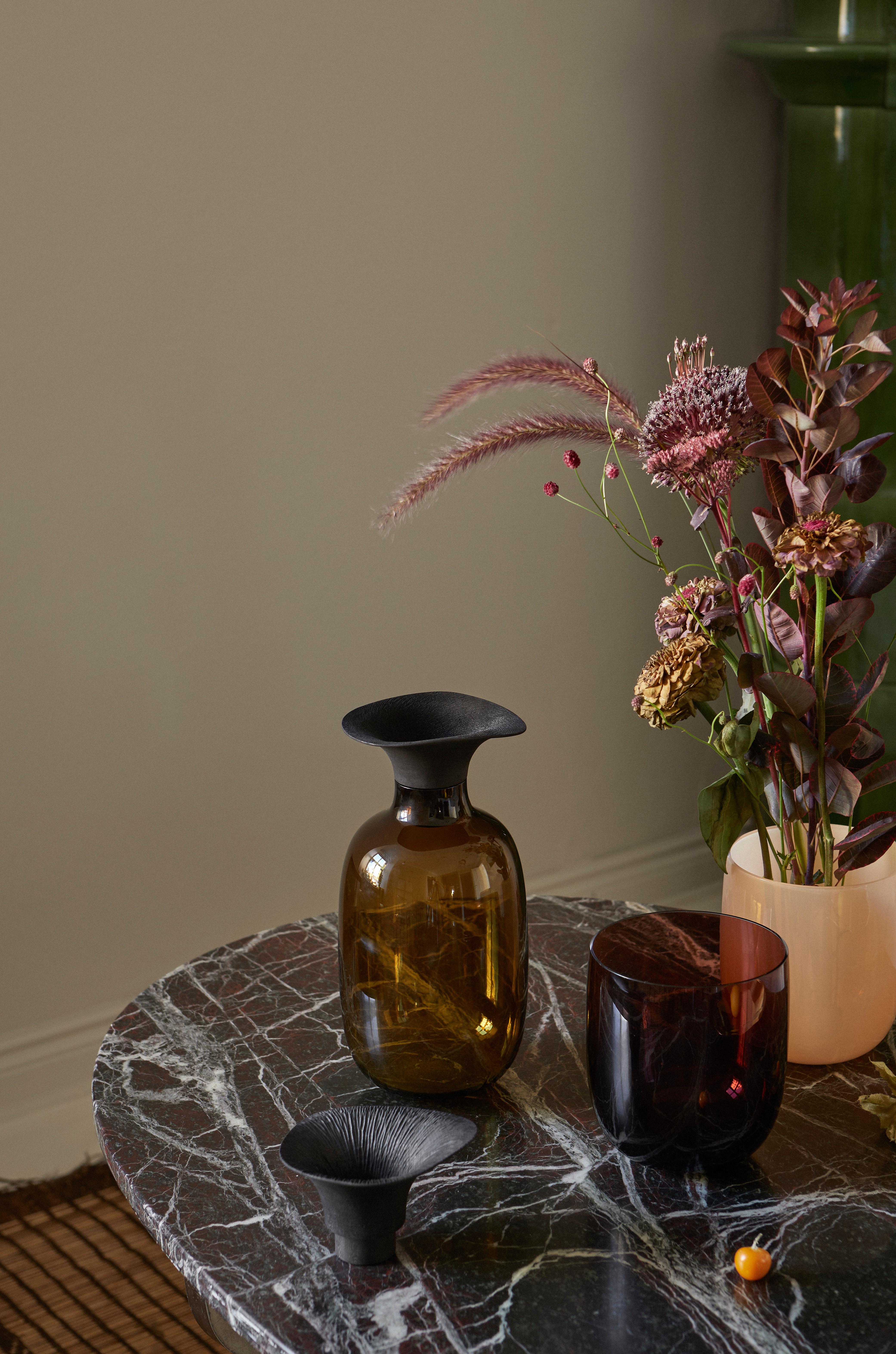 Combining hard glass with warm wood, the Vieno bottle is designed to combine harmoniously with floral arrangements. Vieno is like smooth, calm water: it gives life to flowers and branches that are given to it, letting them reach out towards new
