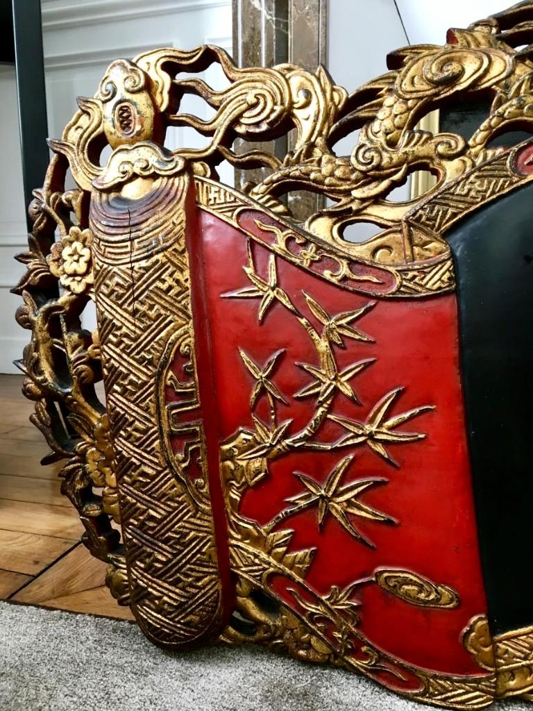 Very nice and important lacquered wood welcome panel from Vietnam dating from the second half of the 19th century. Its carved decoration is very raised and perforated on the periphery presents two dragons at the top in search of the sacred pearl and