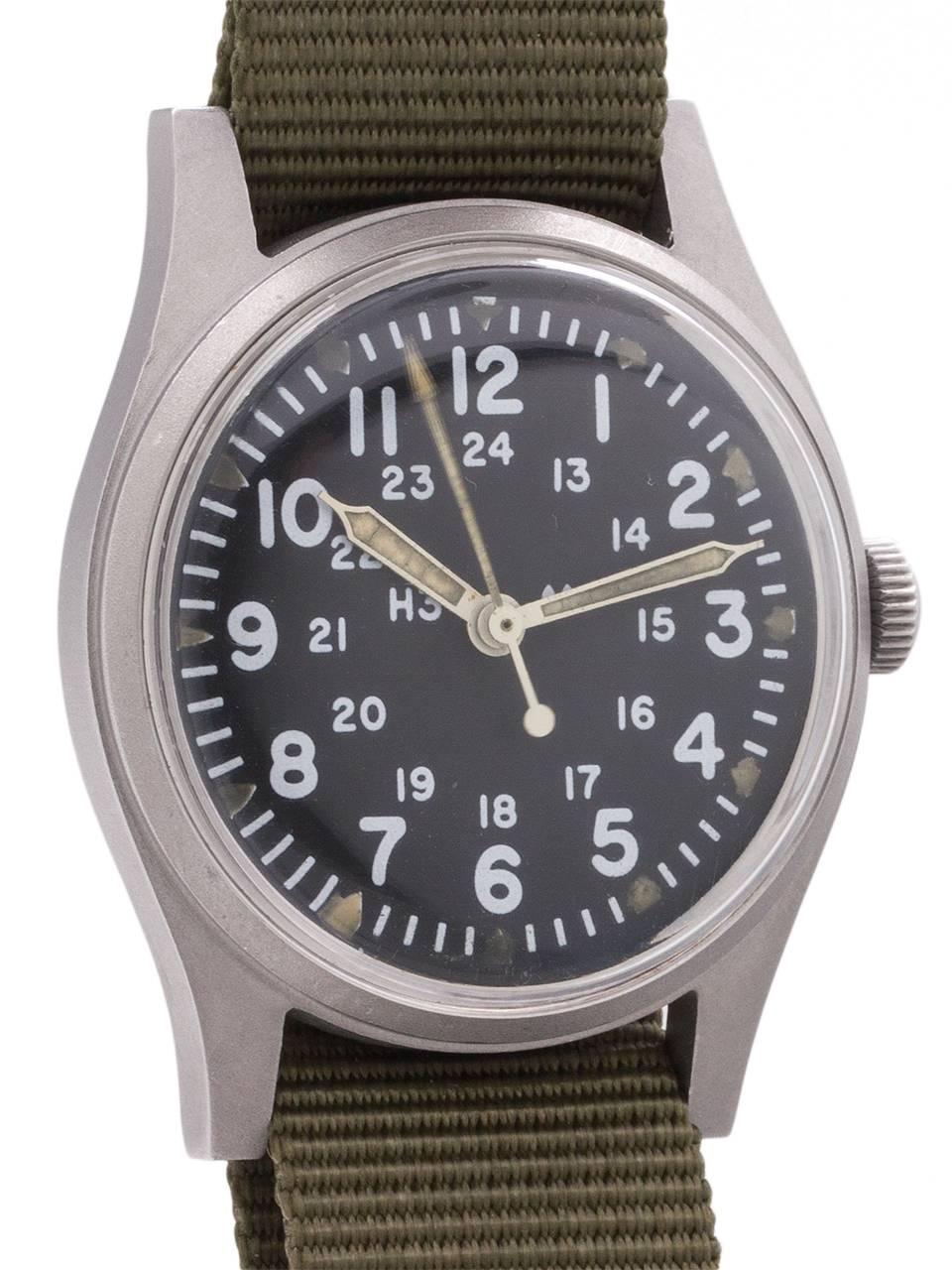 
US Military issue Hamilton man’s wristwatch Vietnam era featuring 34 X 41mm non reflective brushed finish base metal case, acrylic crystal, and original matte black dial with 24 hour indexes and triangular luminous hour indexes, luminous hands and