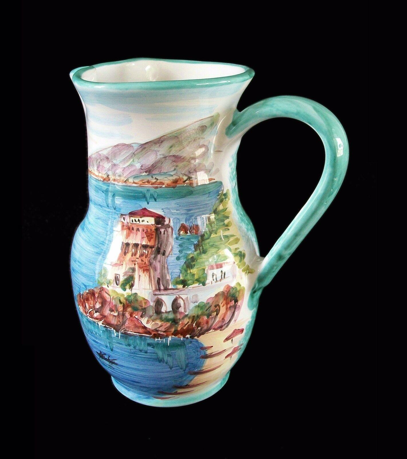 VIETRI - Vintage hand painted and wheel thrown terracotta pitcher - featuring a scenic view of the Amalfi coast - sponge decorated back with white glazed interior - signed on the back and base - Italy - late 20th century.

Excellent/mint vintage
