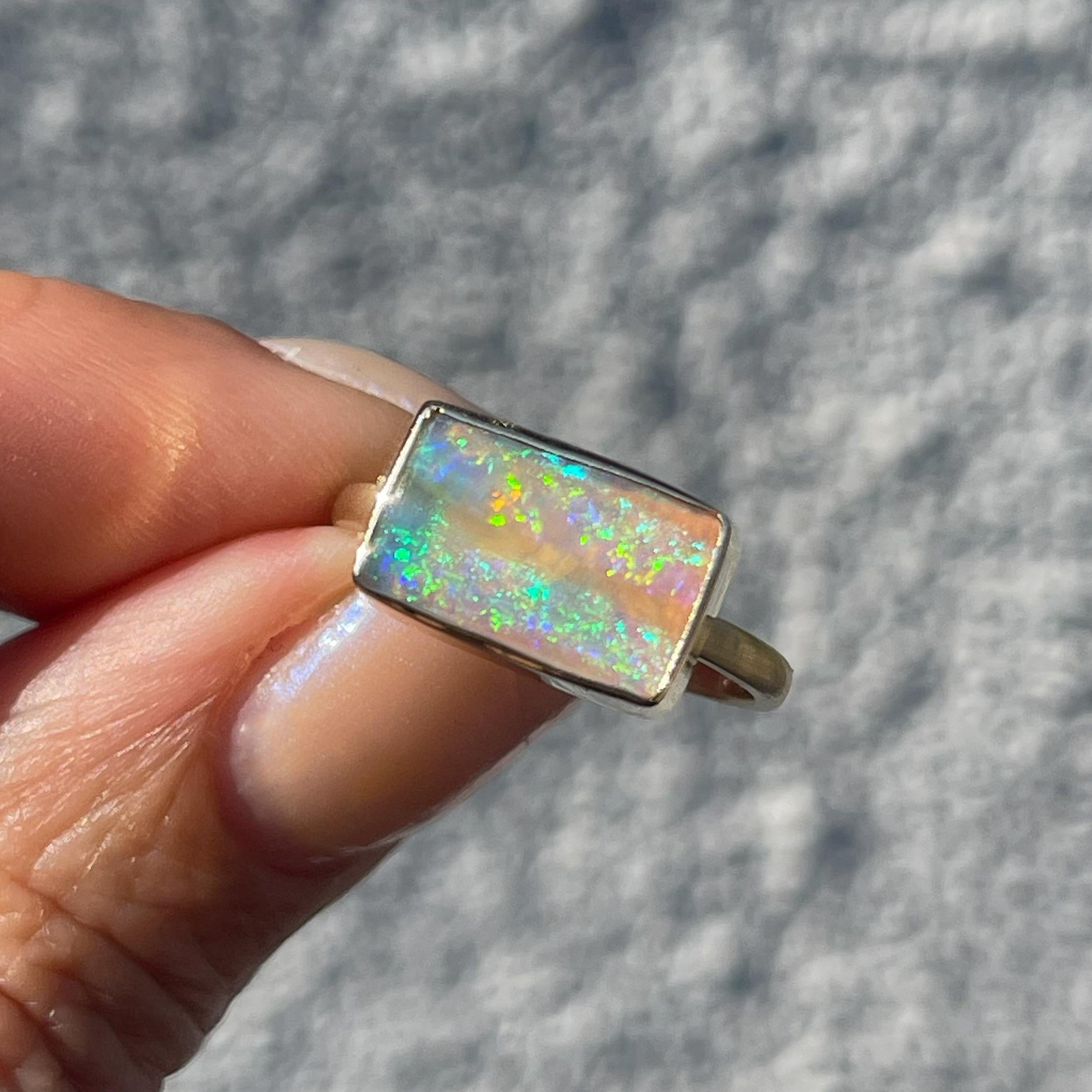 Inside this divine Australian Opal ring, bursts of pigment appear and disperse. Its spectrum of color is intense and elusive; wrapped neatly in the frame of the gold opal ring. With each subtle movement, the colors shift, yet the range of hues