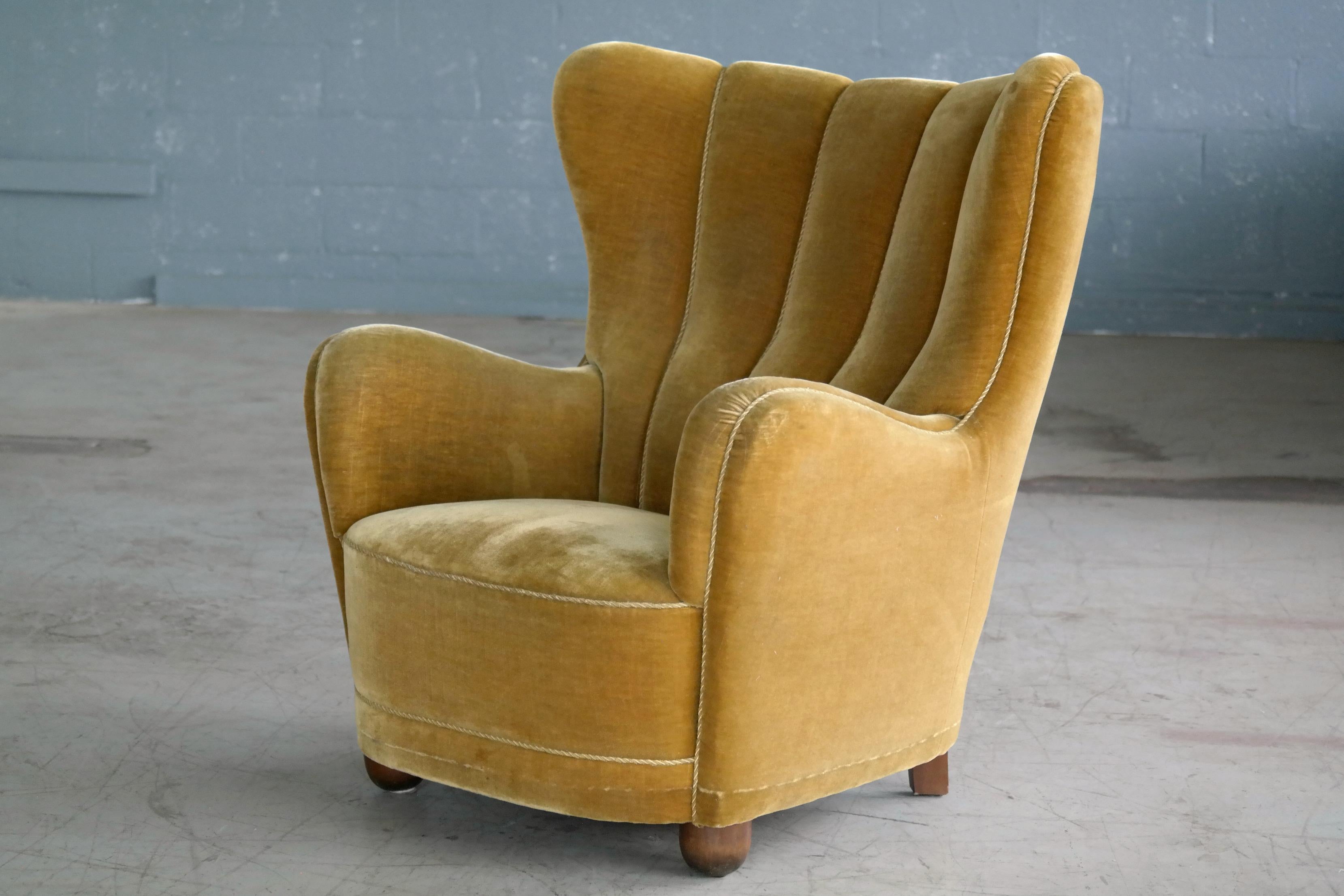 Fantastic Danish 1940s high back armchair with a golden yellow mohair fabric. The chair is much in the style of Viggo Boesen and Flemming Lasssen especially with the ball shaped front legs typical for many of Boesen's designs and the voluptuous yet
