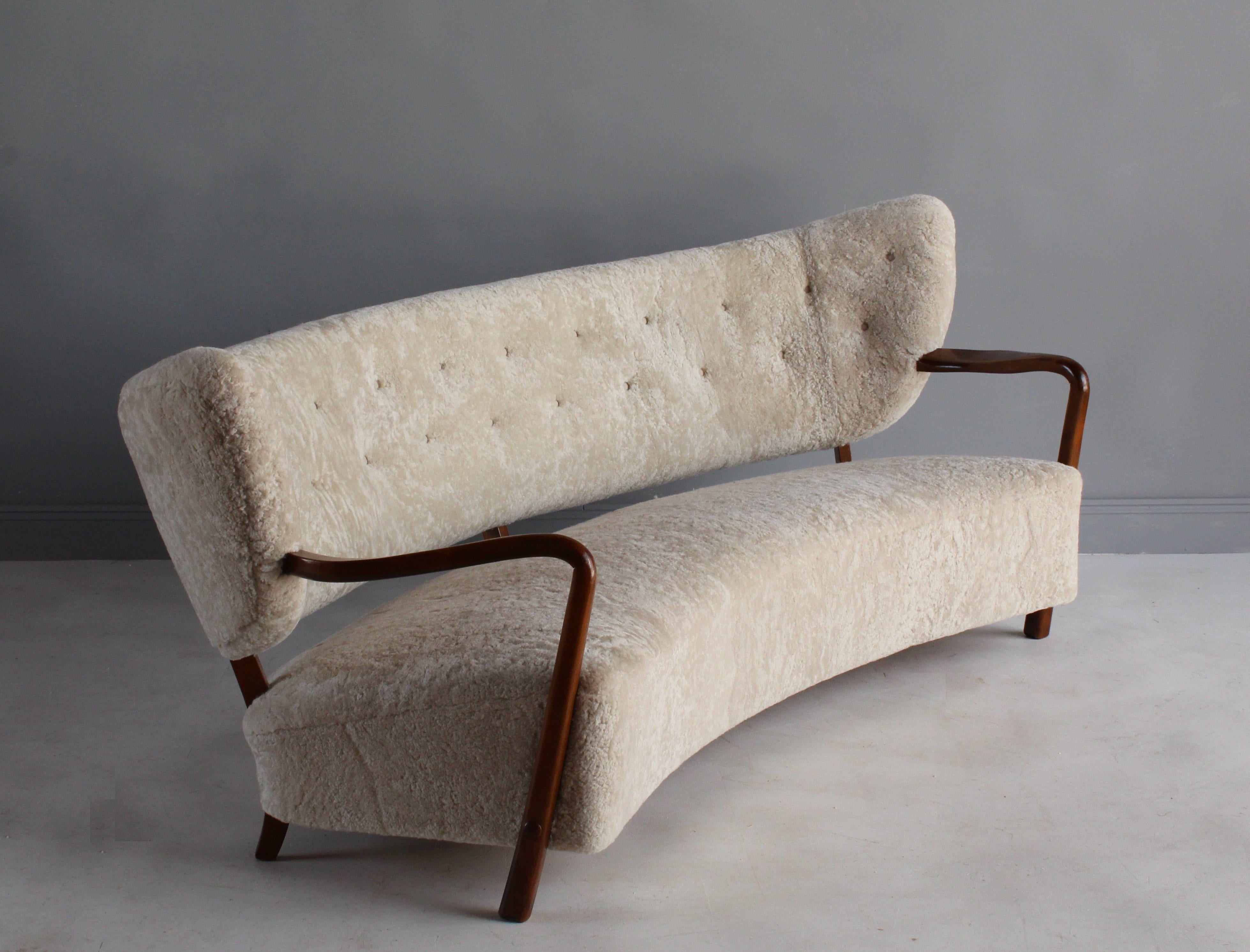 A highly modernist 1940s sofa attributed to Danish architect and designer Viggo Boesen. The soft organic / biomorphic form the sofa is enhanced by the authentic sheepskin / lambskin upholstery. 

Other nordic designers include Kaare Klint, Philip