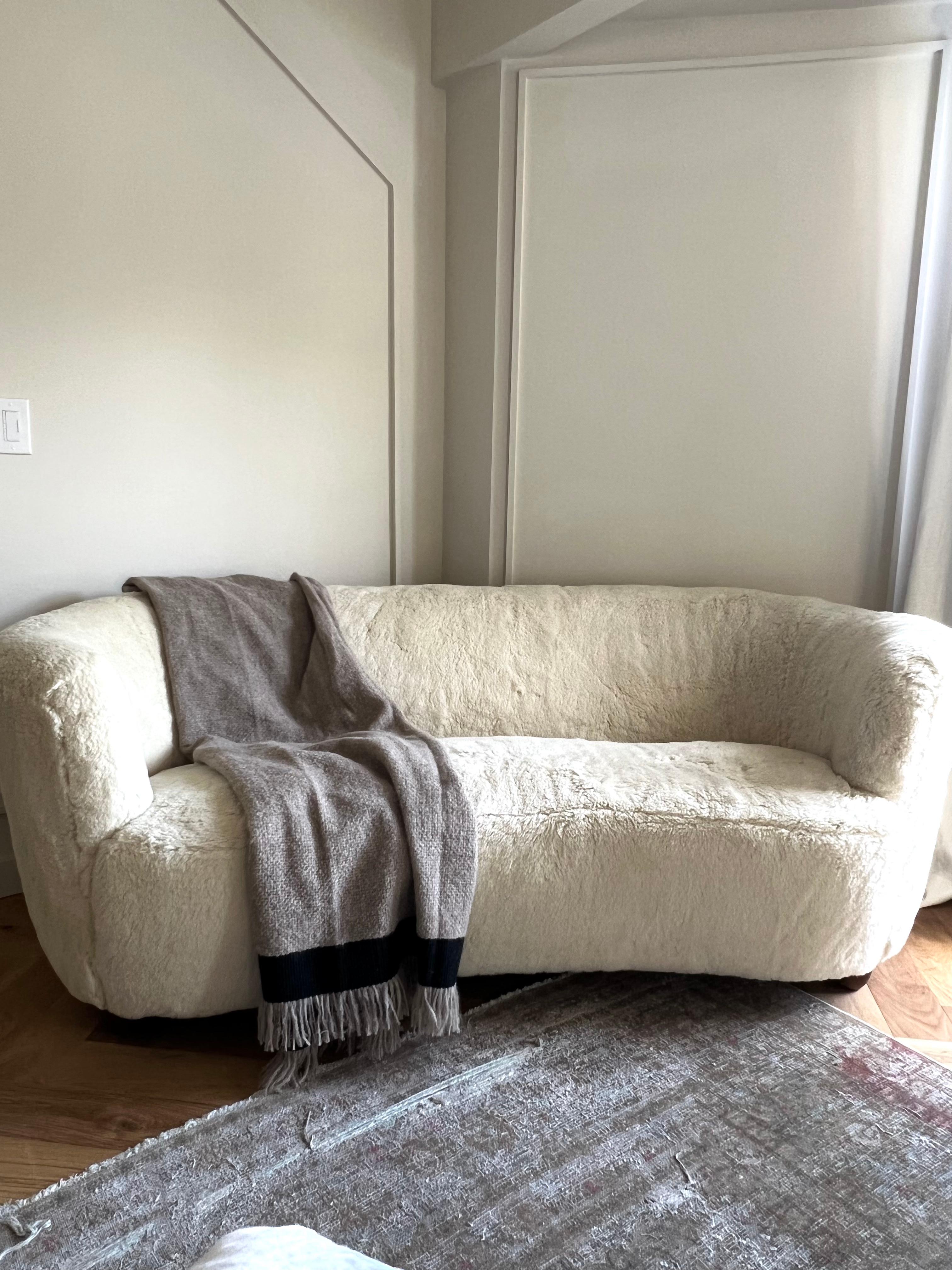1930s Viggo Boesen banana shaped sofa/loveseat with channel back. Vintage MCM Danish design refurbished in 2019 and reupholstered in high quality cream shearling.
