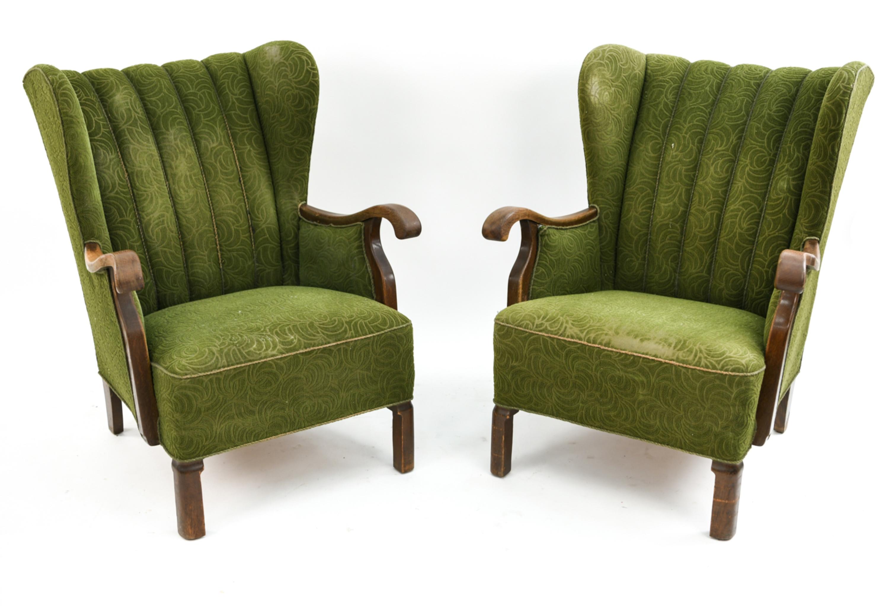 This is a magnificent pair of wingback lounge chairs designed by Viggo Boesen for Slagelse Mobelvaerk, circa 1940s. These early Danish midcentury chairs feature ribbed backs with exposed wood details including the elegantly shaped armrests. As a