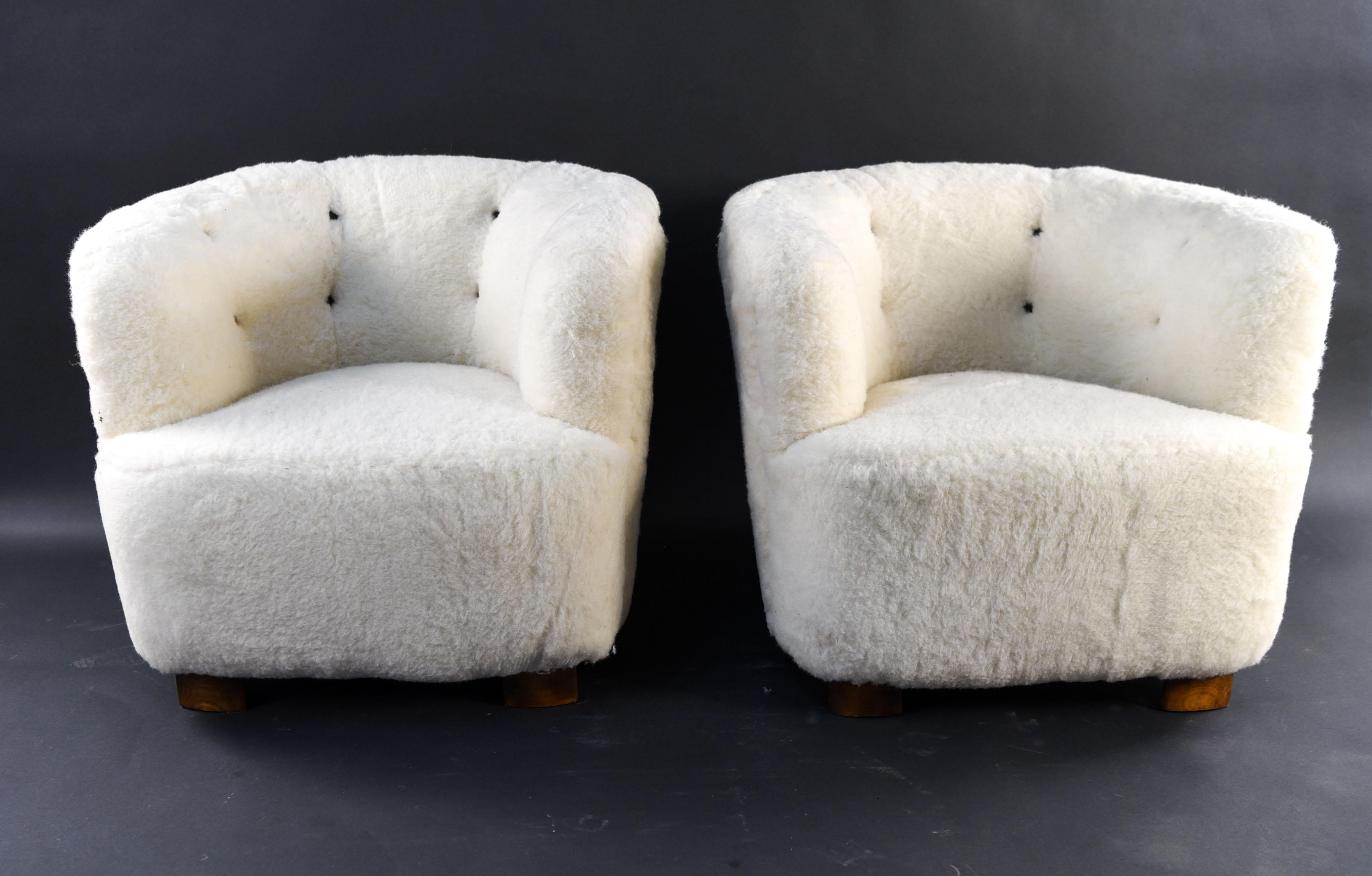This beautiful art deco inspired pair of Danish midcentury lounge chairs were designed by Viggo Boesen for Slagelse Mobelvaerk. The epitome of comfort, these chairs are upholstered in a lamb's wool with a tufted back detail.