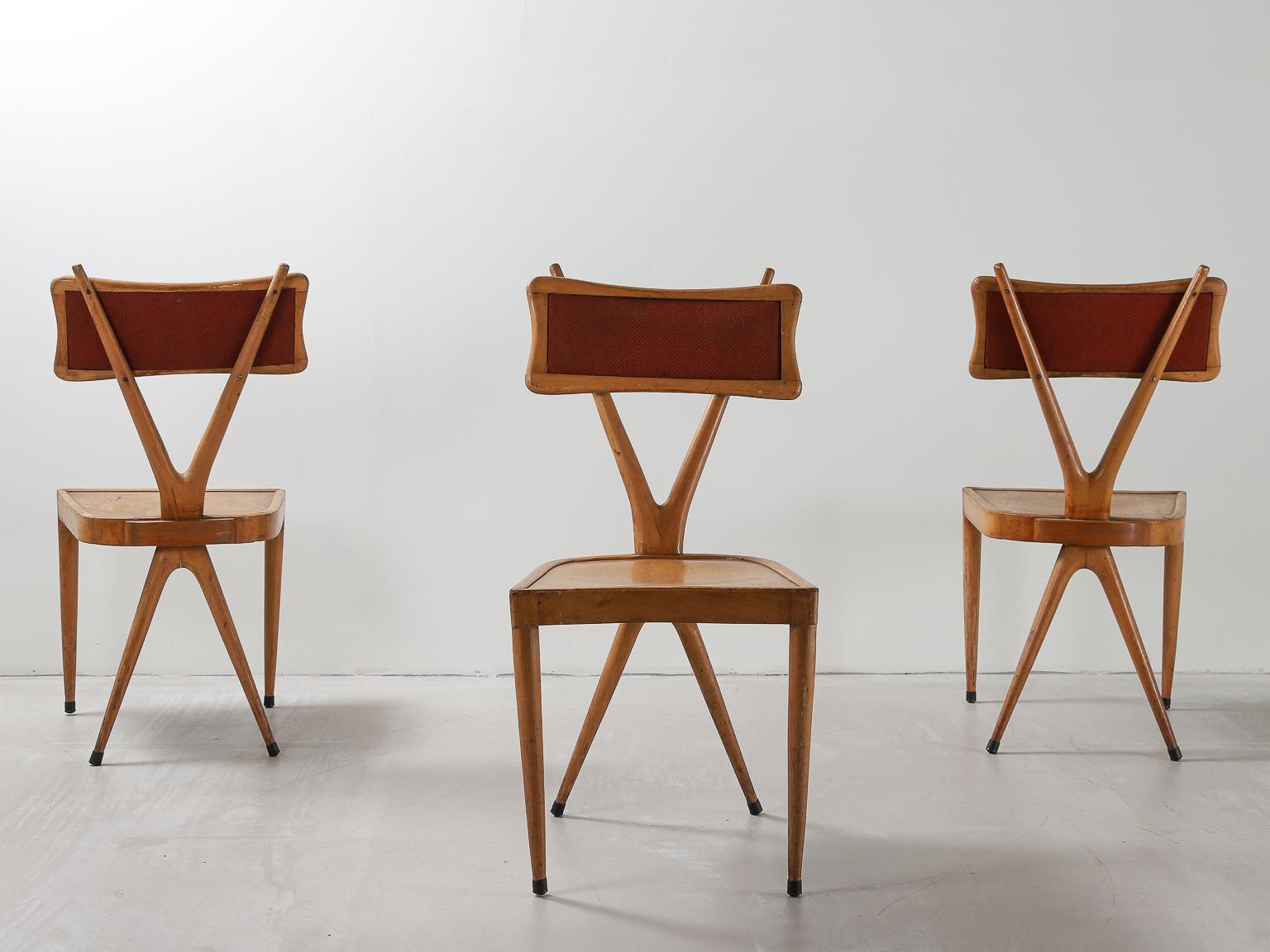 A set of 3 Vigorelli Gianni smooth, polished beech wood and fabric chairs from the 1950s, with characteristic X-shaped backrests, original rectangular upholstery and tapered legs.