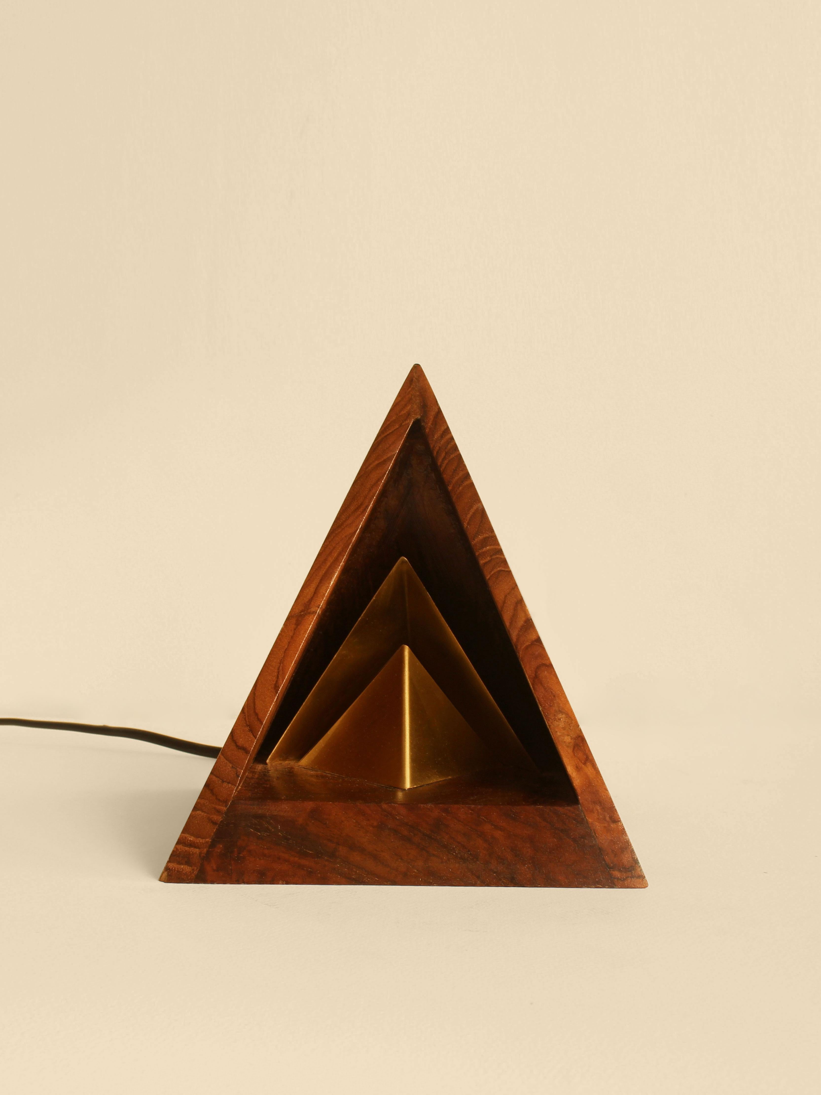 Vihaan Table Lamp by Studio Indigene
Dimensions: D 14 x W 14 x H 17.14 cm
Materials: Reclaimed Teak Wood, Brass.
Colors Brown, Natural Wooden, Brass Finish.

Vihaan, born from experiments with indirect light, casts a golden glow, perfect for setting