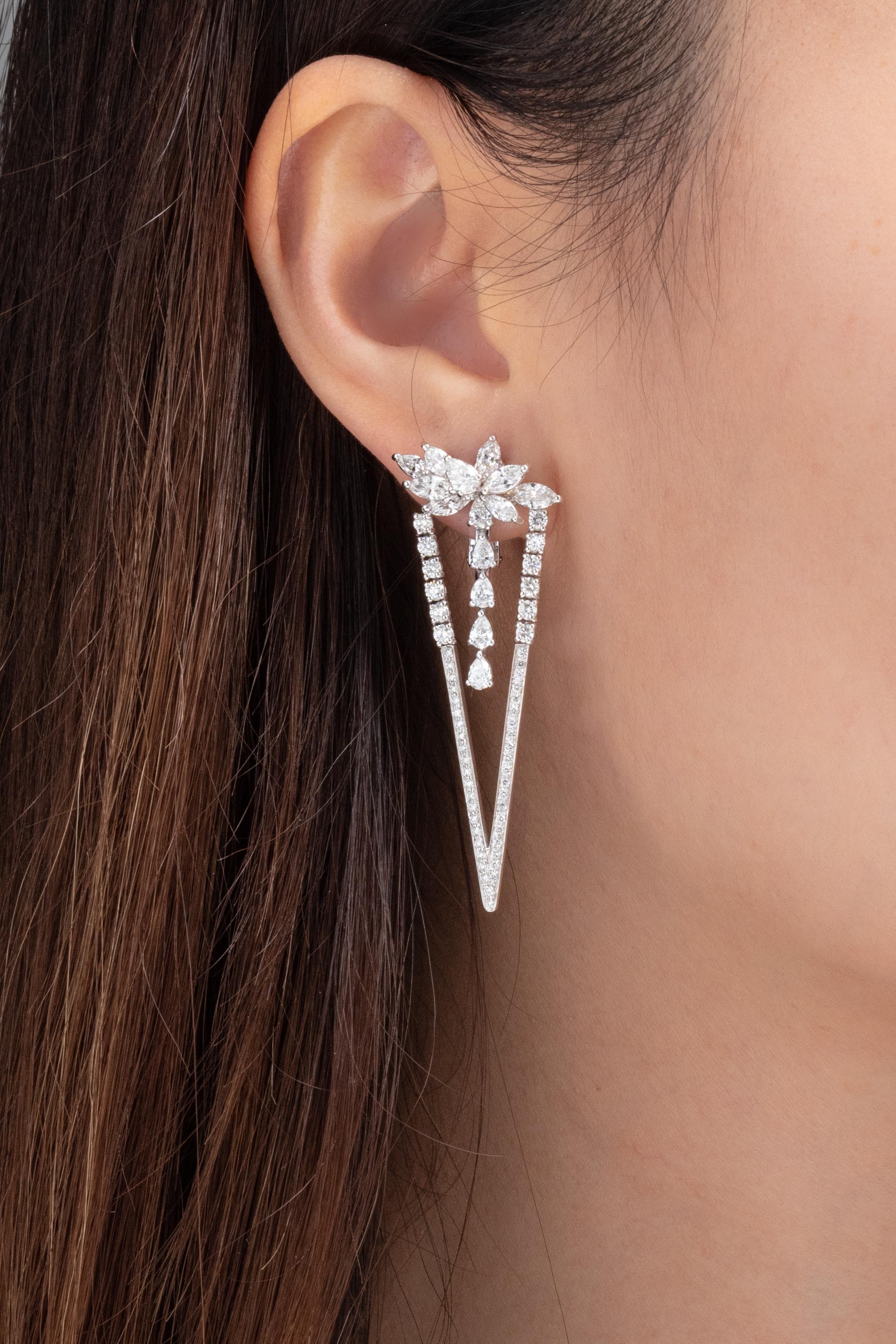 Sculptural lines and shape juxtaposition inspired this pair of diamond earrings by Vihari Jewels. The earrings are set in 18K White Gold and feature 16 marquise shaped diamonds, 12 pear shaped diamonds, and 118 round shaped diamonds. All diamonds