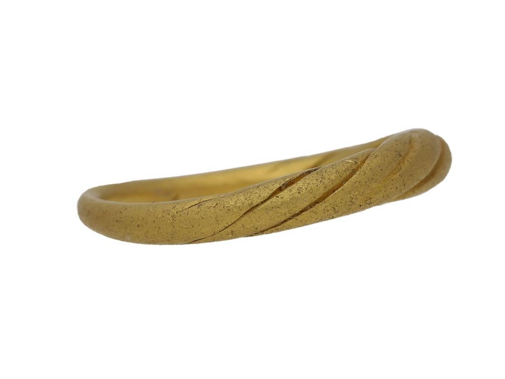 Anello vichingo con incisione in oro. Un anello in oro giallo, con linee riccamente incise che suggeriscono fili d'oro intrecciati, che si assottigliano fino a formare un solido gambo arrotondato, del peso di circa 7,73 grammi. Oro giallo testato,