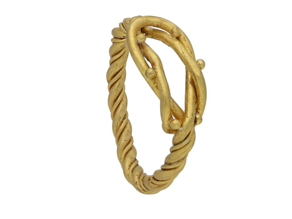 Viking gold Hercules knot ring. A yellow gold ring consisting of two rounded solid gold wires entwined in a finely worked Hercules knot with granulated detail, the two wires twisted and fused together on the shoulders to form a solid shank to the