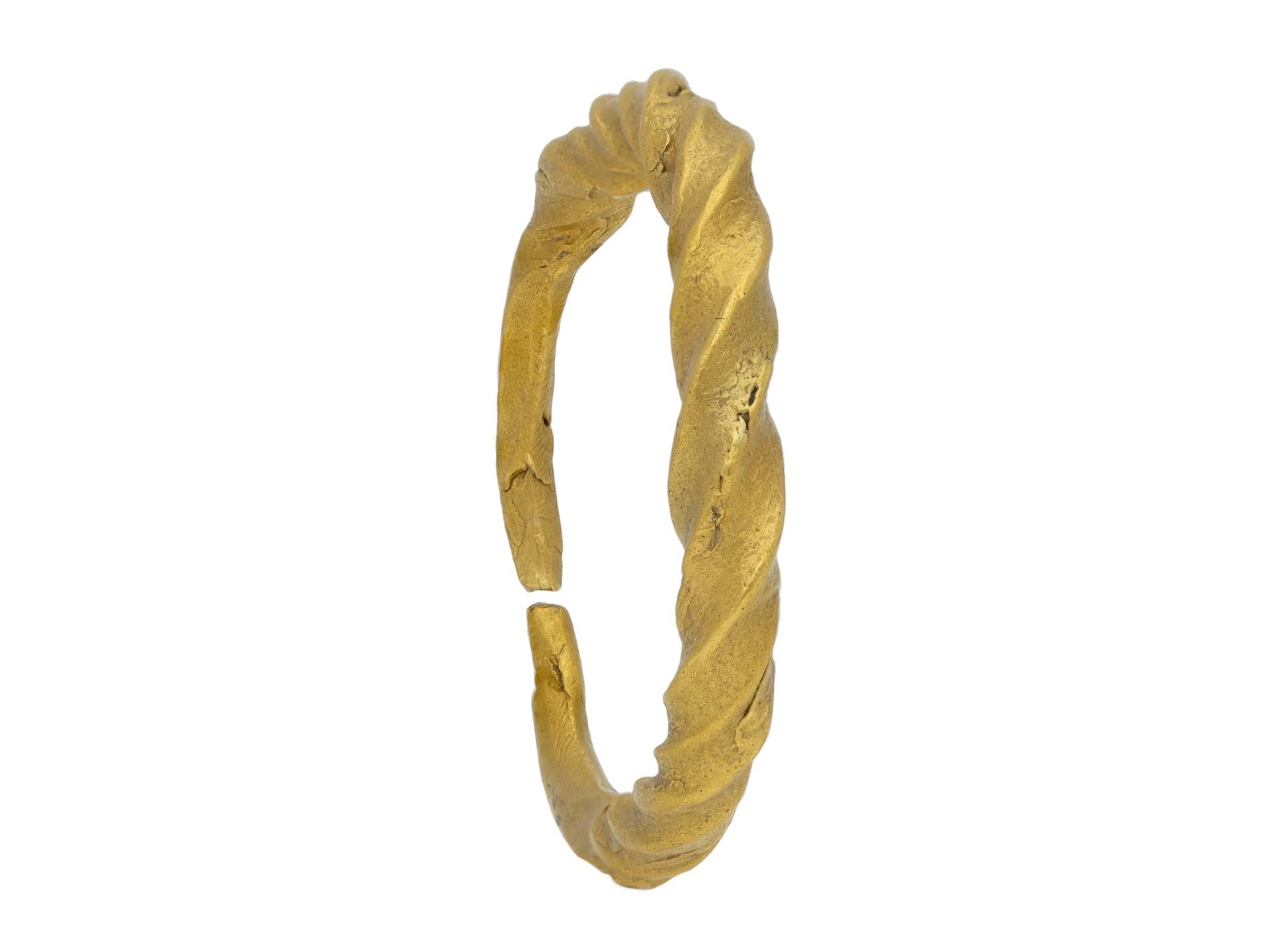 Viking gold penannular twisted ring. A yellow gold ring formed of a single twisted gold rod, graduating from center, the ends of the rod drawn out to a solid tapering rounded open closure at reverse. Tested yellow gold, approximately 7.75 grams in
