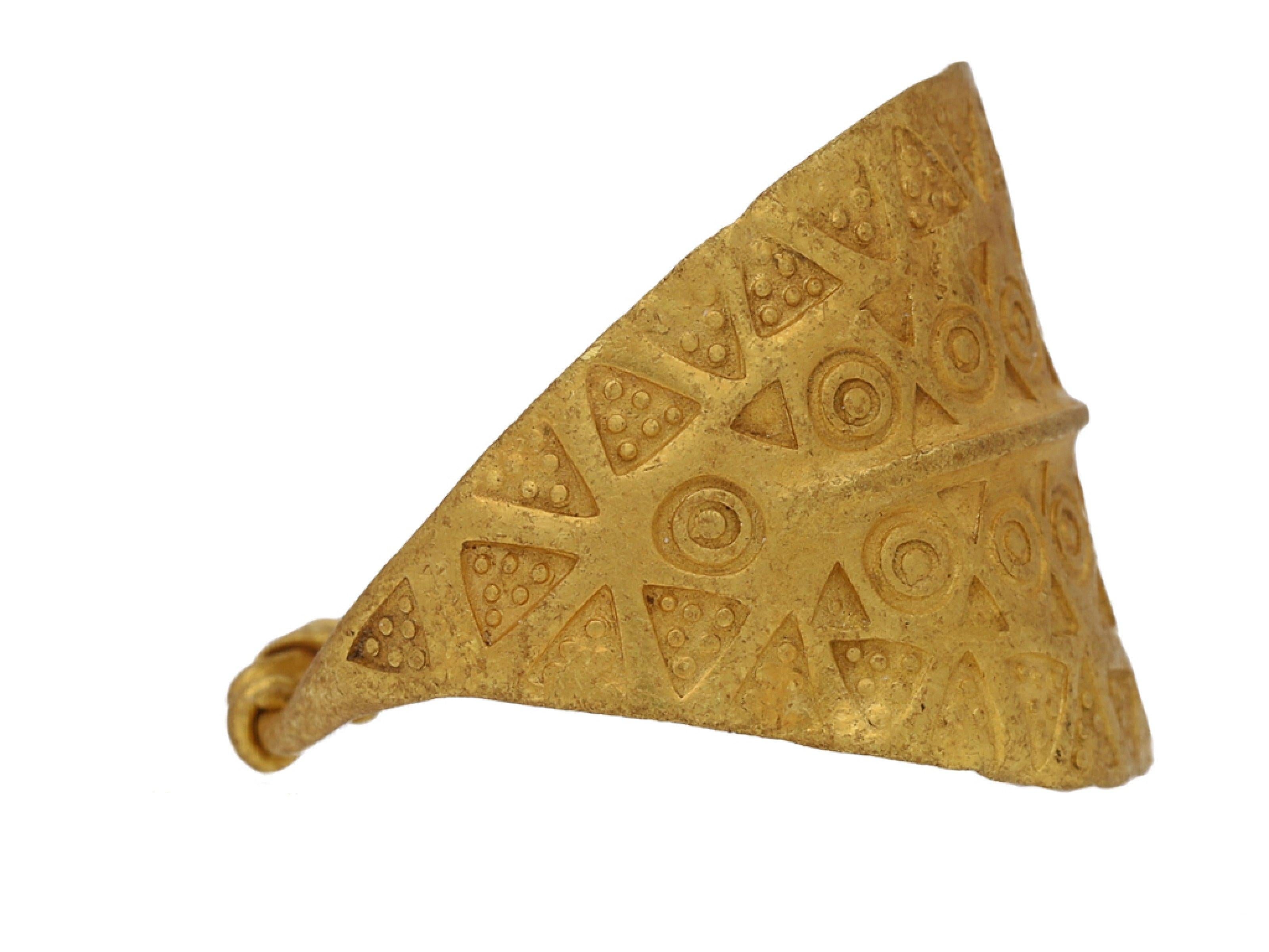Bague en or estampillée Viking. Une grande bague en or jaune comportant une plaque incurvée en forme de bombe, avec des détails linéaires en relief au centre et décorée d'une série d'estampilles triangulaires et circulaires répétées, les épaules