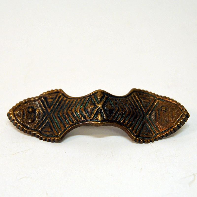 Special vintage and Viking inspired oval bronze brooch by Kalevala Koru, Finland 1940s. Great natural patina with lovely relieffs and decor.
Stamped on the back with Made in Finland and makers Hallmark. Size of brooch: 7 cmL x 2 cmD x 0.1 cmT. Good
