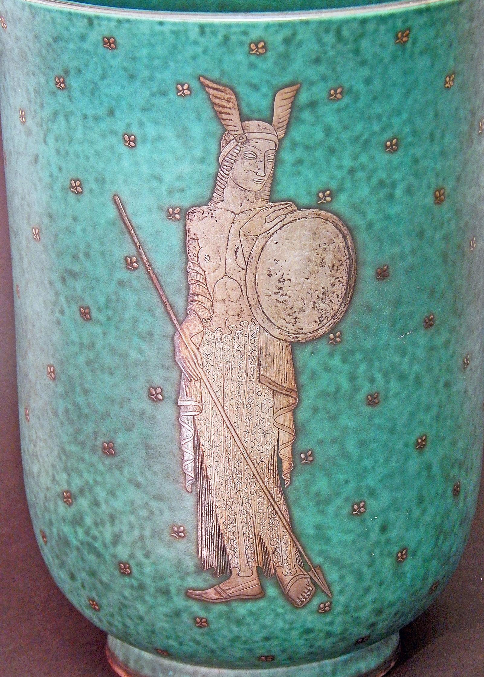 One of the largest and most remarkable Argenta pieces we have ever offered, this vase depicts a half-nude Viking princess, fully equipped with the regalia of her station, including shield, staff and winged helmet. The Argenta line of ceramics