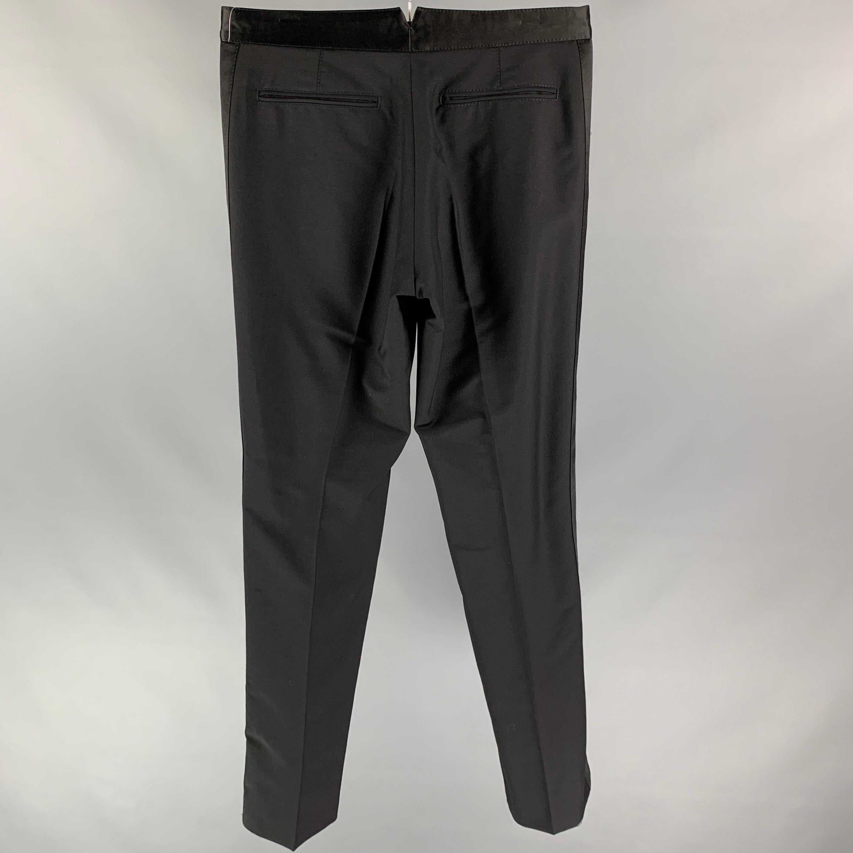 VIKTOR & ROLF tuxedo dress pants comes in a black wool / mohair featuring a flat front, straight leg, front tab, and a zip fly closure. Made in Italy.

Very Good Pre-Owned Condition.
Marked: 50

Measurements:

Waist: 32 in.
Rise: 9.5 in.
Inseam: 35