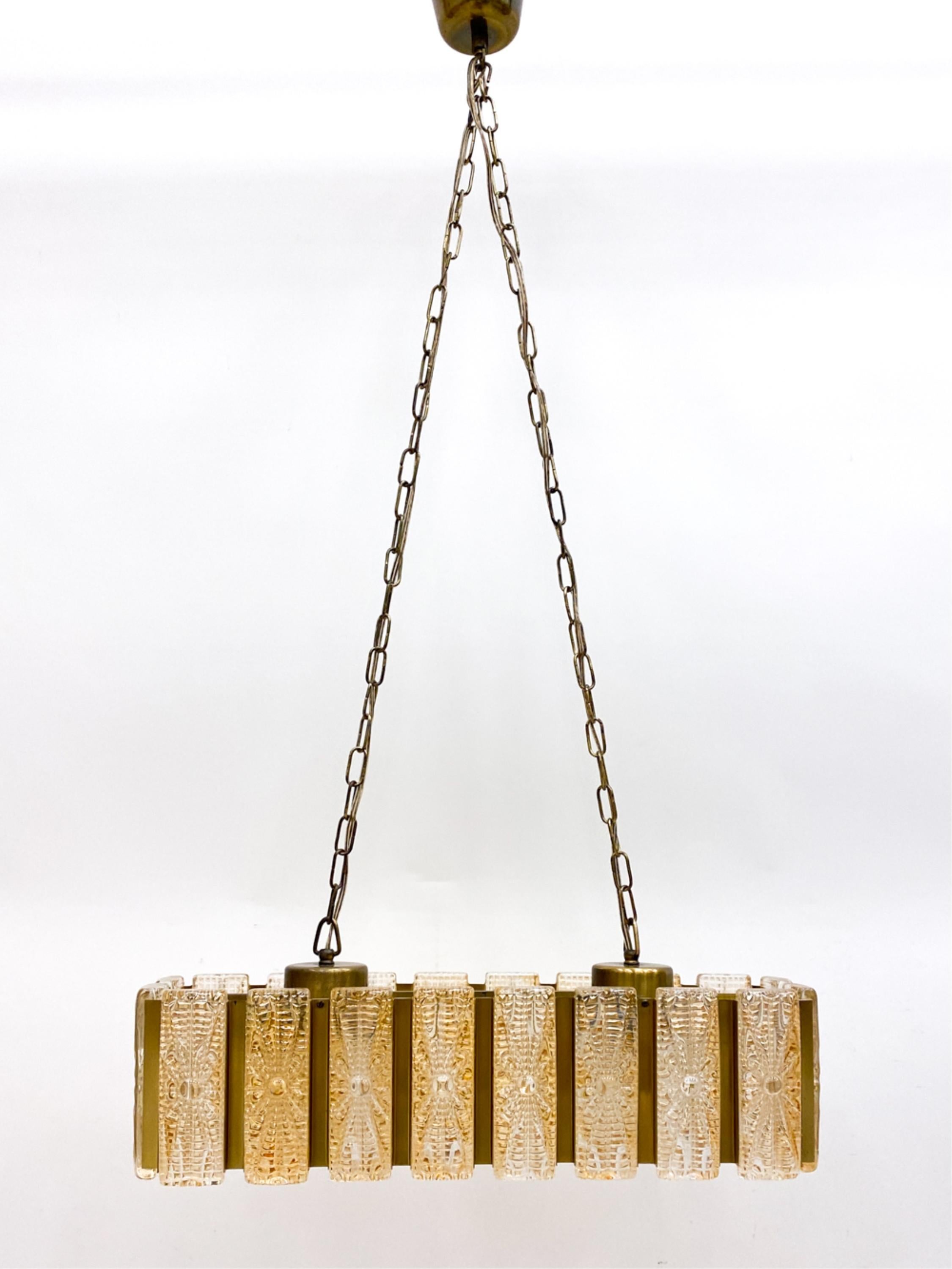 This ceiling light is the epitome of Danish lighting design. This piece was crafted sometime in the 1960's and is iconic for the time period. Combining the craftmanship of Danish glass makers with the timeless elegance of brass, this hanging pendant
