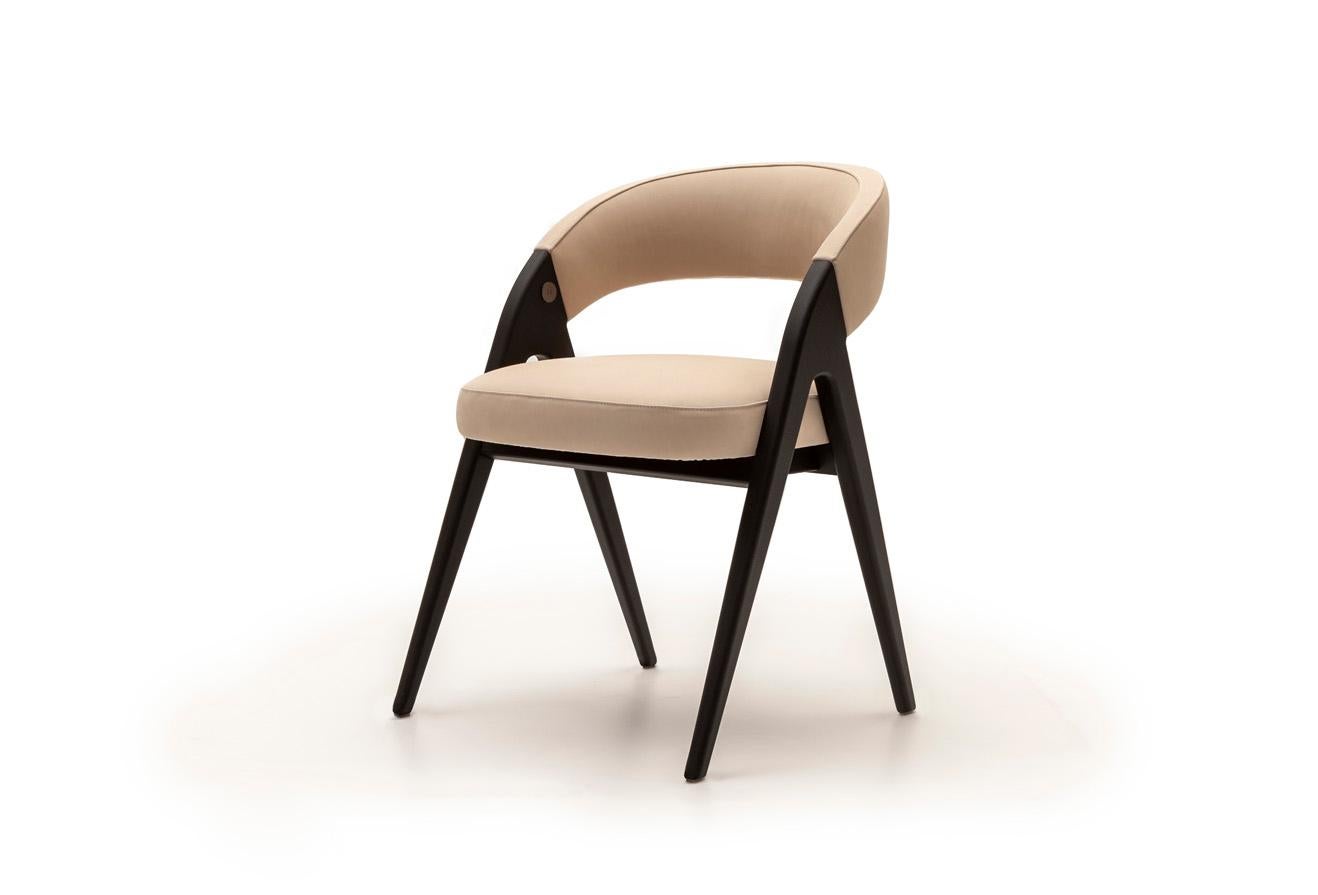 Introducing a stunning piece of furniture - a solid wood chair with a retro feel, given a modern twist. The design boasts a sleek, single line starting from the easel legs and extending all the way up to the upholstery back. This exquisite piece is