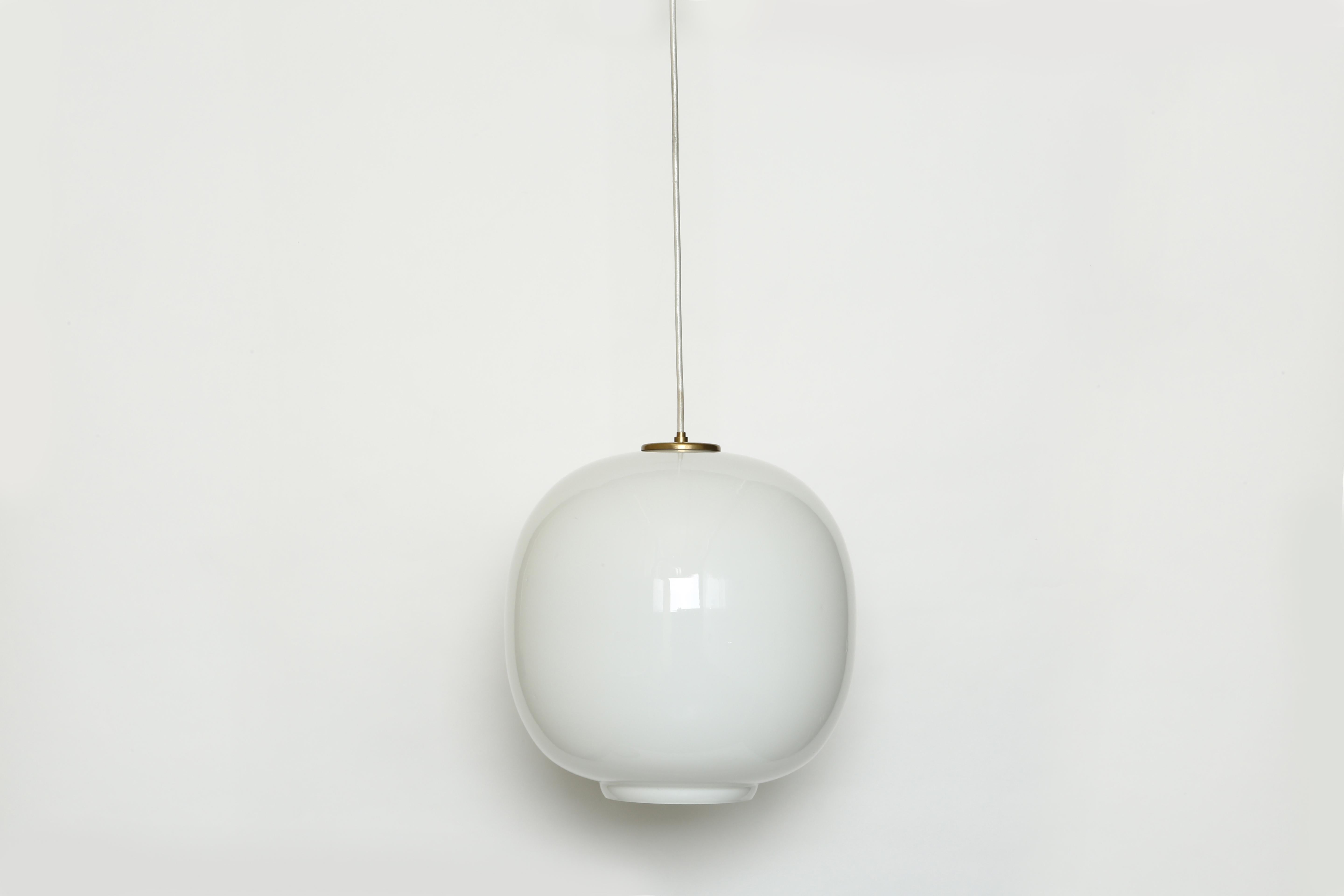 Ceiling pendant by Vilhelm Lauritzen for Louis Poulsen.
Made in Denmark in 1950s. Handmade opaline glass and brass.
Danish architect Vilhelm Lauritzen designed those pendants for Radio House in Copenhagen. 
This is the largest pendant out of the