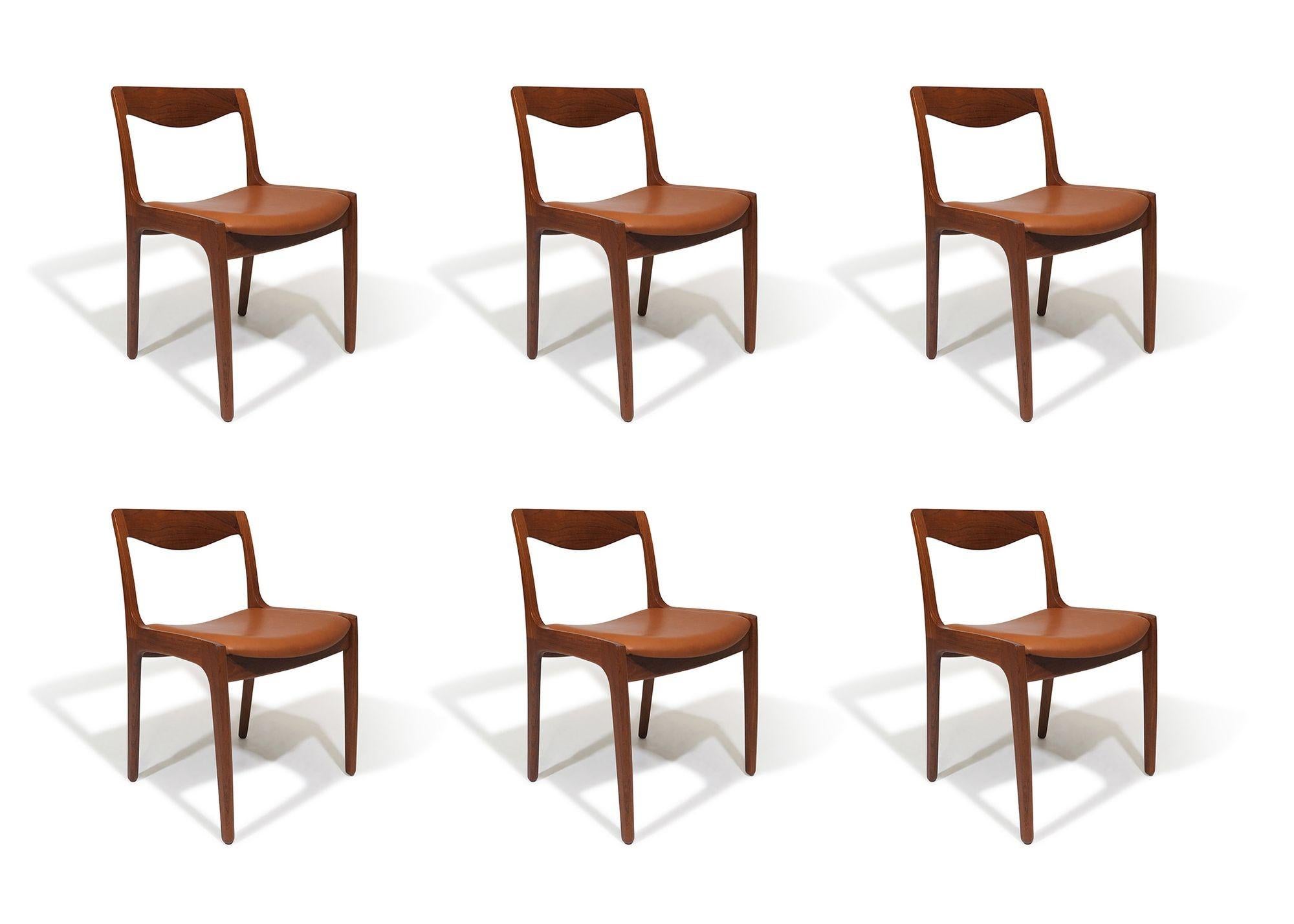 Midcentury Danish dining chairs designed by Vilhelm Wohlert for Poul Jeppesen Møbelfabrik, Denmark, 1956. The chairs feature finely sculpted solid-teak backrests on teak frames, showcasing exposed finger joinery. The set of chairs have been fully