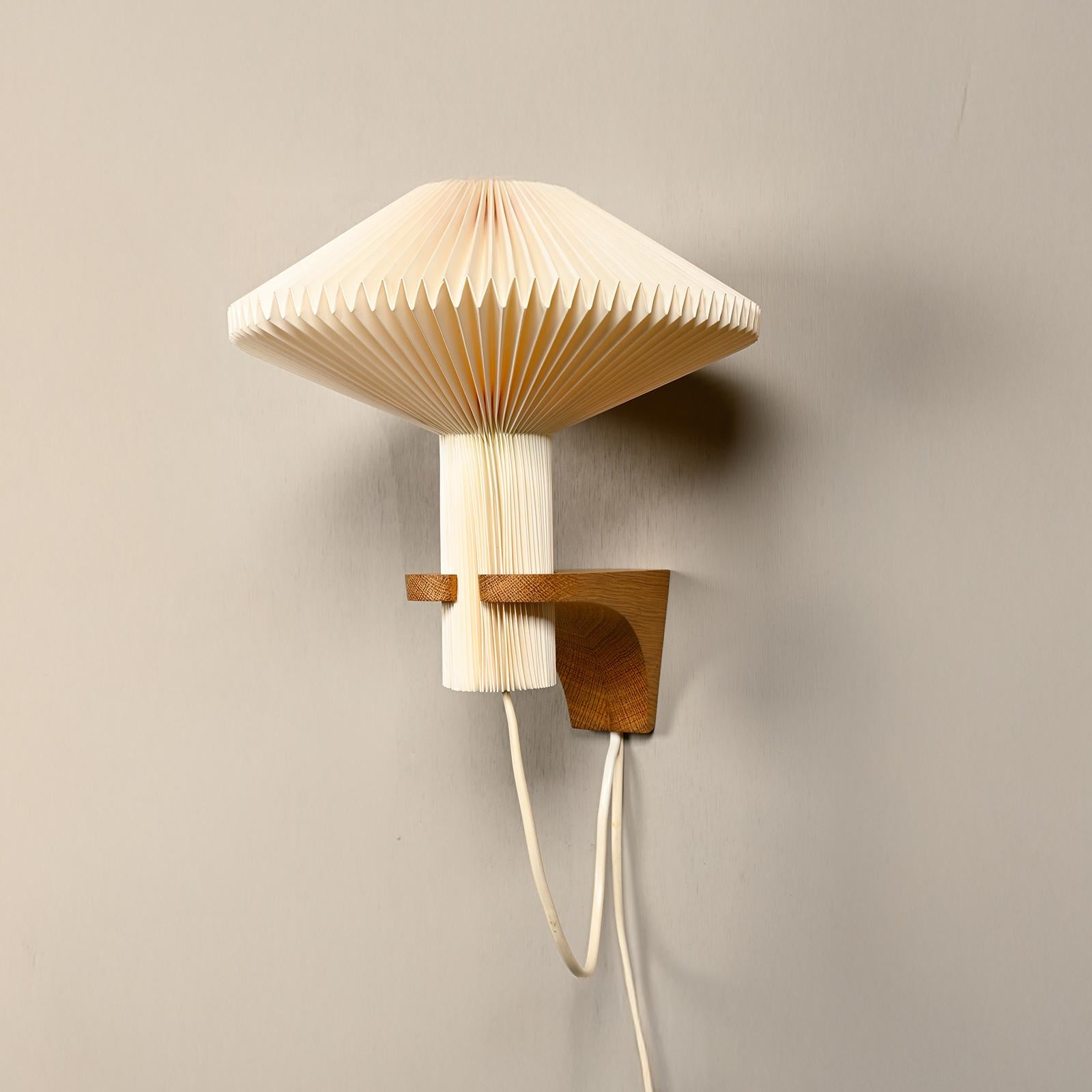 Rare early wall lamp (Model 204) designed in 1957 by Vilhelm Wohlert for Le Klint. Original designed for Niels Bohr summer house outside Copenhagen. Solid oak mount with hand folded acrylic lampshade. Mount in excellent condition. Lampshade with