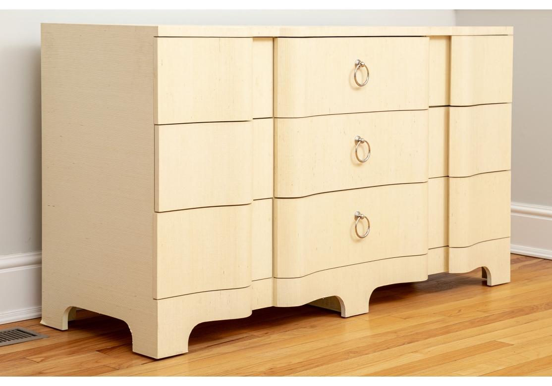 Villa & House Bardot Collection 9 drawer art deco style chest covered in neutral lacquered grasscloth that flows over each cresting drawer front and around each corner. Accentuated by polished nickel ring hardware, glided drawers and resting