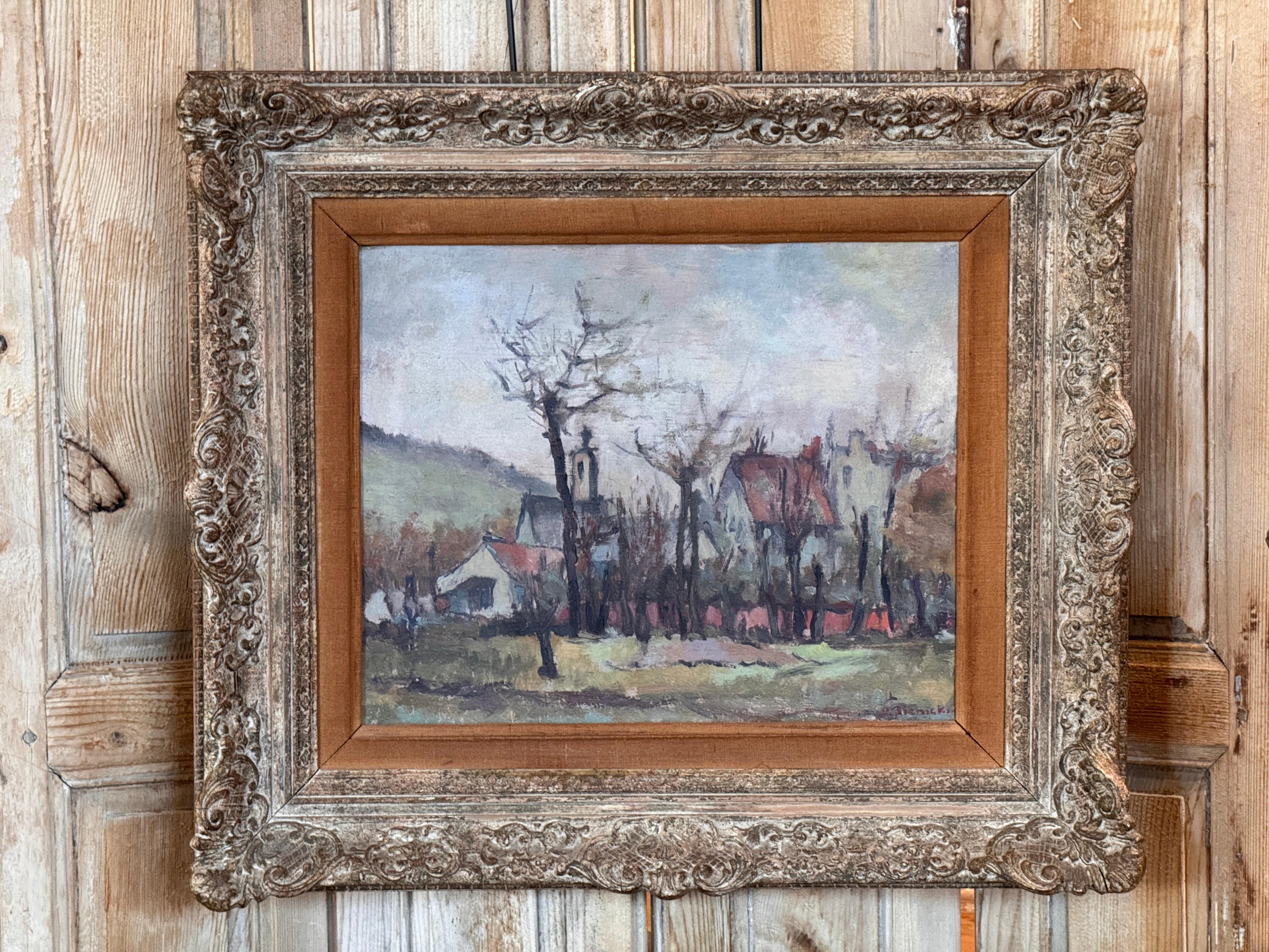 Olio su tela francese della metà del XX secolo di George René Sinicki che raffigura un tranquillo villaggio con la guglia della chiesa e le case dai tetti rossi sotto un cielo morbido e coperto. Dipinta in stile post-impressionista, l'opera presenta