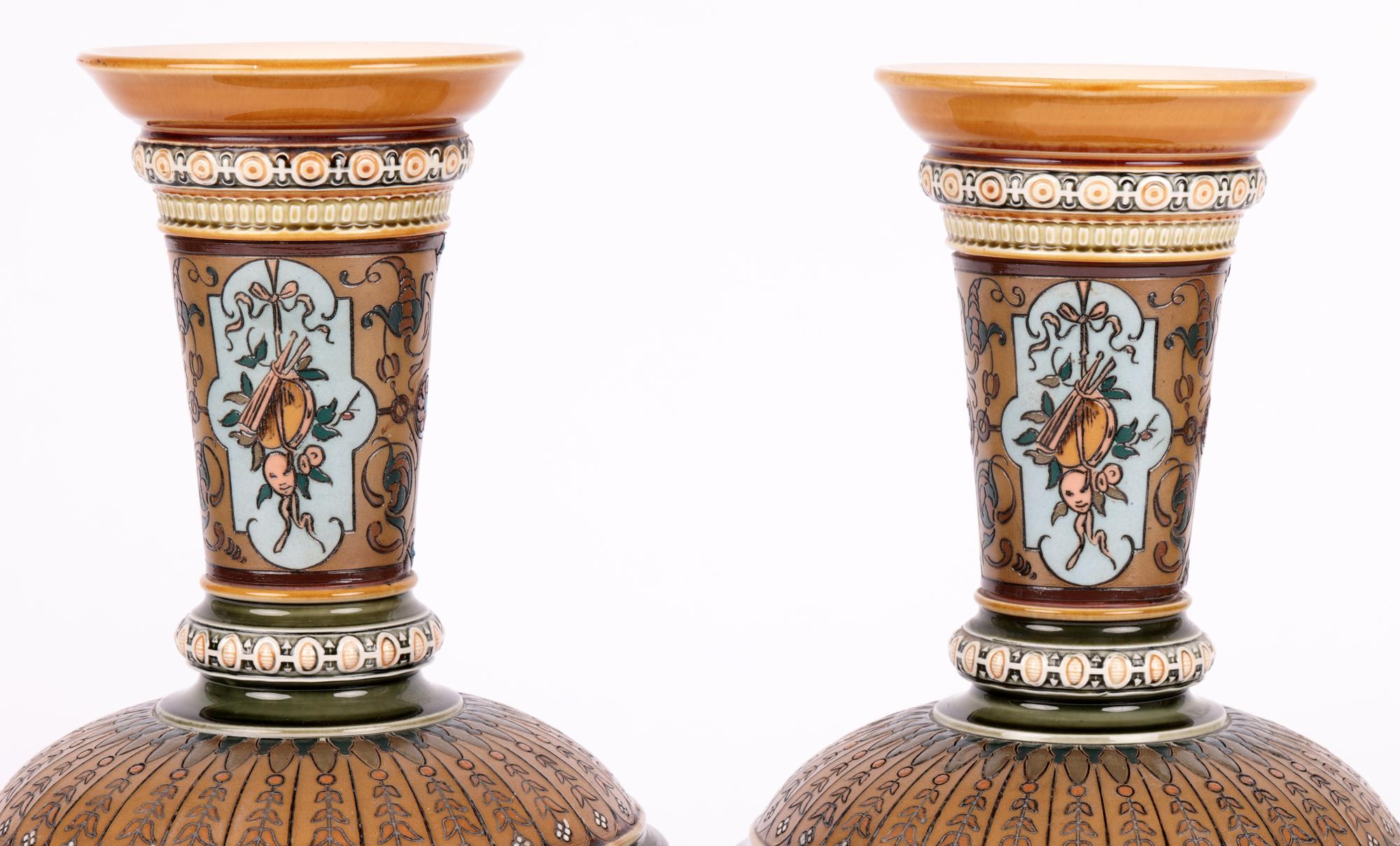 A stunning and large pair German villeroy boch mettlach Art Nouveau pedestal vases decorated with panels containing boys dated 1895. The vases stand raised on a narrow domed round foot with a wide round rouleau shaped body with incised petal designs