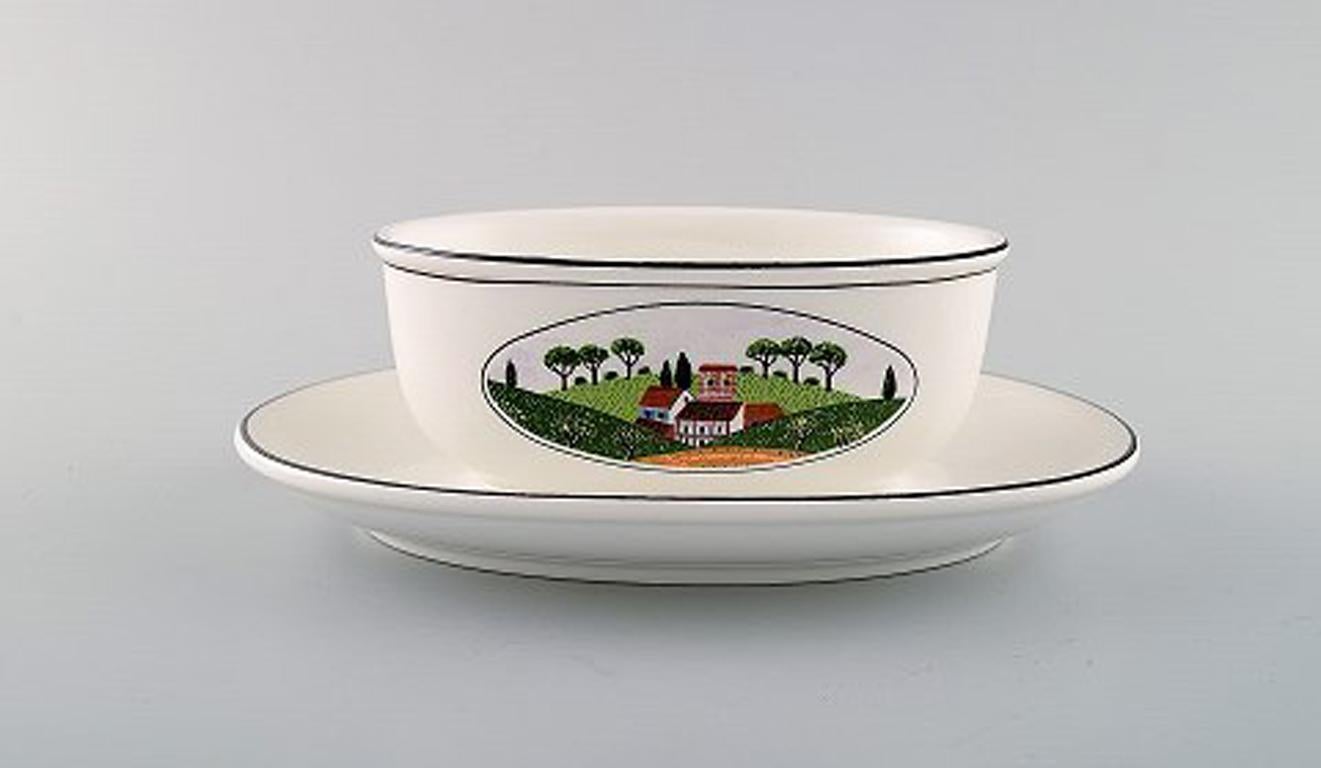 Villeroy & Boch Naif gravy boat on stand in porcelain decorated with naivist village motif.
In very good condition.
Stamped.
Measures: 20.5 x 14.5 x 7 cm.
Designed by Gérard Laplau. Motives of families, villages and biblical scenes in naivist
