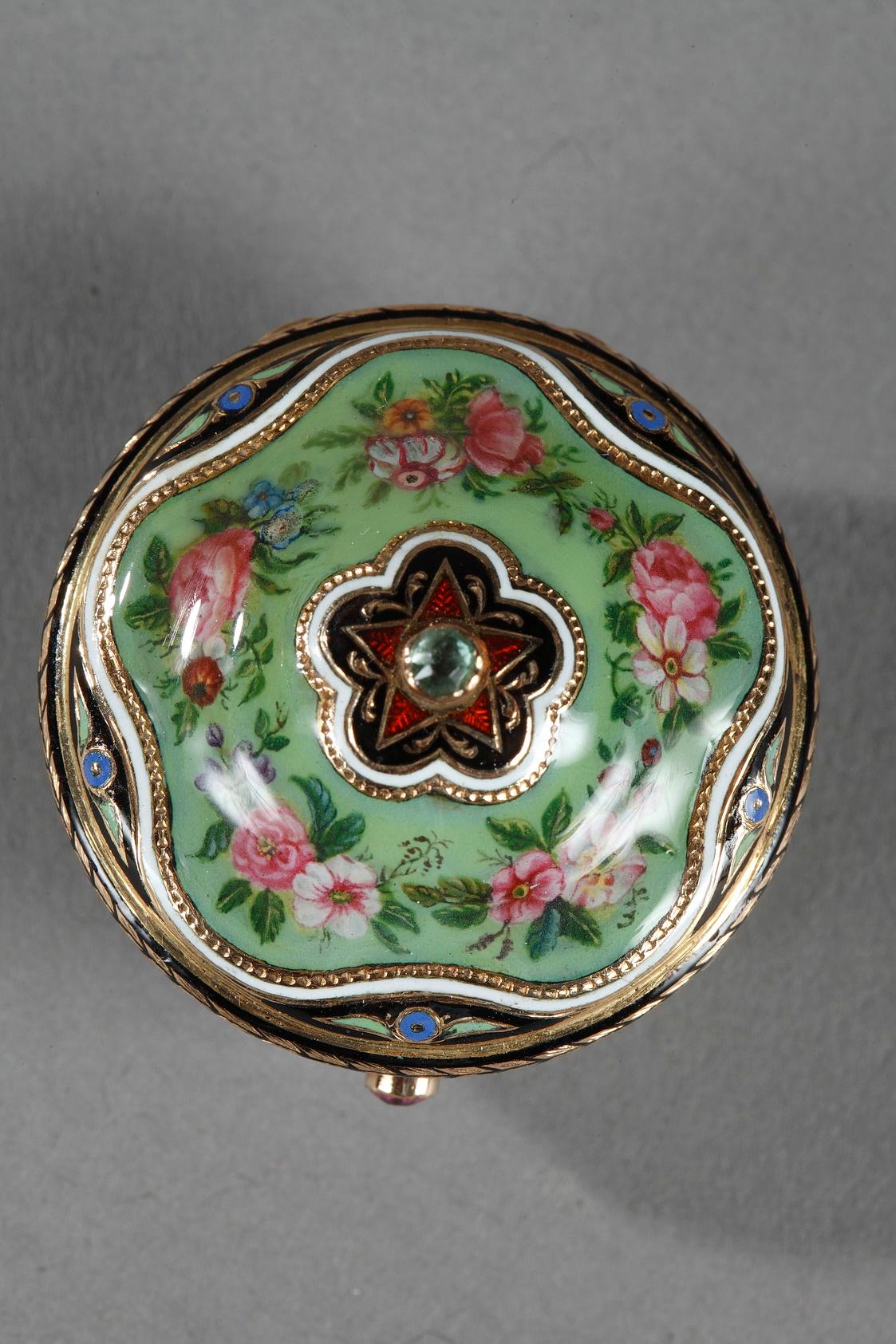 Pot-shaped, gold vinaigrette in green enamel embellished with a multicolored floral motif. The hinged lid is decorated with a flowers and topped with a translucent, red enamel star and a precious stone in the center. The body of the vinaigrette