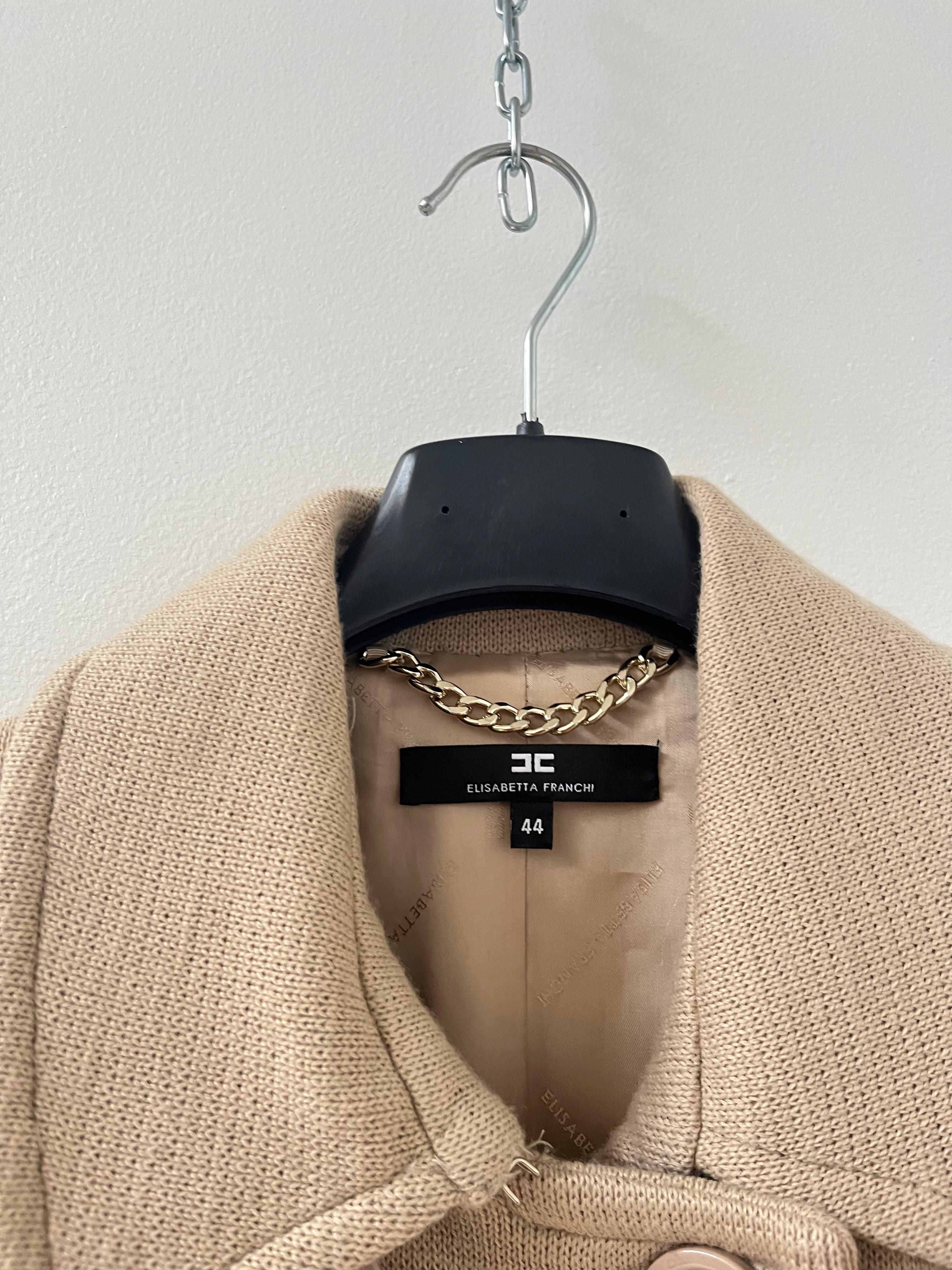 Step into timeless sophistication with this exquisite Elisabetta Franchi double-breasted coat, crafted in a luxurious blend of virgin wool. The warm beige hue and structured silhouette reflect the Italian brand’s dedication to modern elegance and