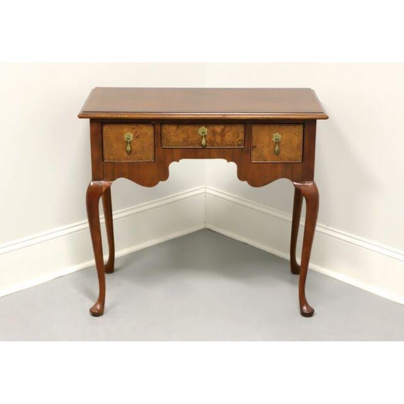 A Queen Anne style side table by top-quality furniture maker Baker Furniture, of North Carolina, USA. Mahogany with inlaid banding to top and burl walnut inlays to drawer fronts. Features three dovetail drawers with brass hardware. Made in the late