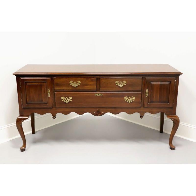 A Queen Anne style sideboard by Ethan Allen, from their Georgian Court Collection. Made from solid cherry with brass hardware, carved apron, cabriole front legs and pad feet. Features three dovetail drawers with faux lock on lower drawer and two