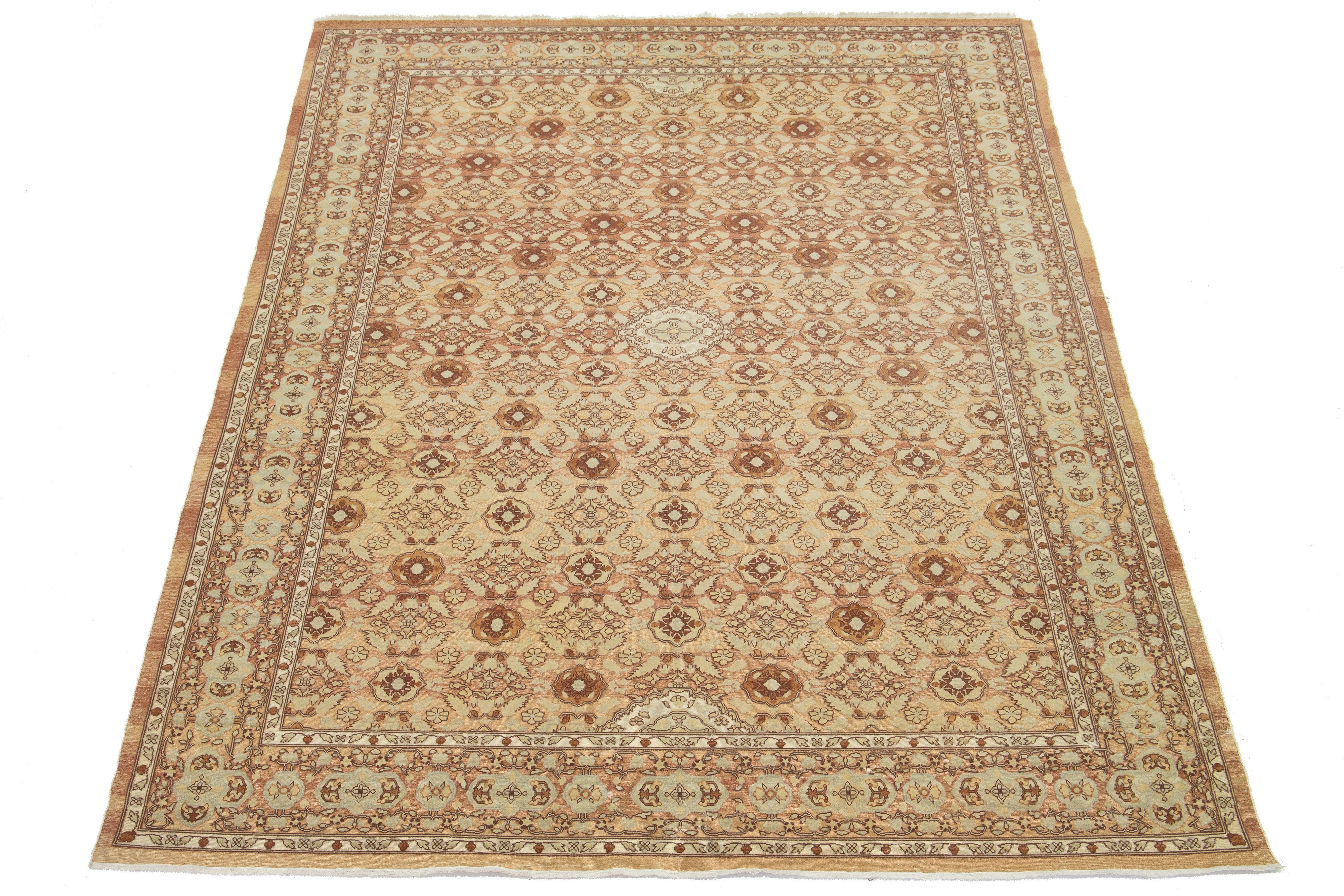 Questo tappeto orientale di ottima fattura, caratterizzato da un medaglione centrale simmetrico e da intricati motivi floreali e geometrici nei ricchi toni del marrone chiaro, del beige e del crema. Incorniciato da bordi a strati con delicati