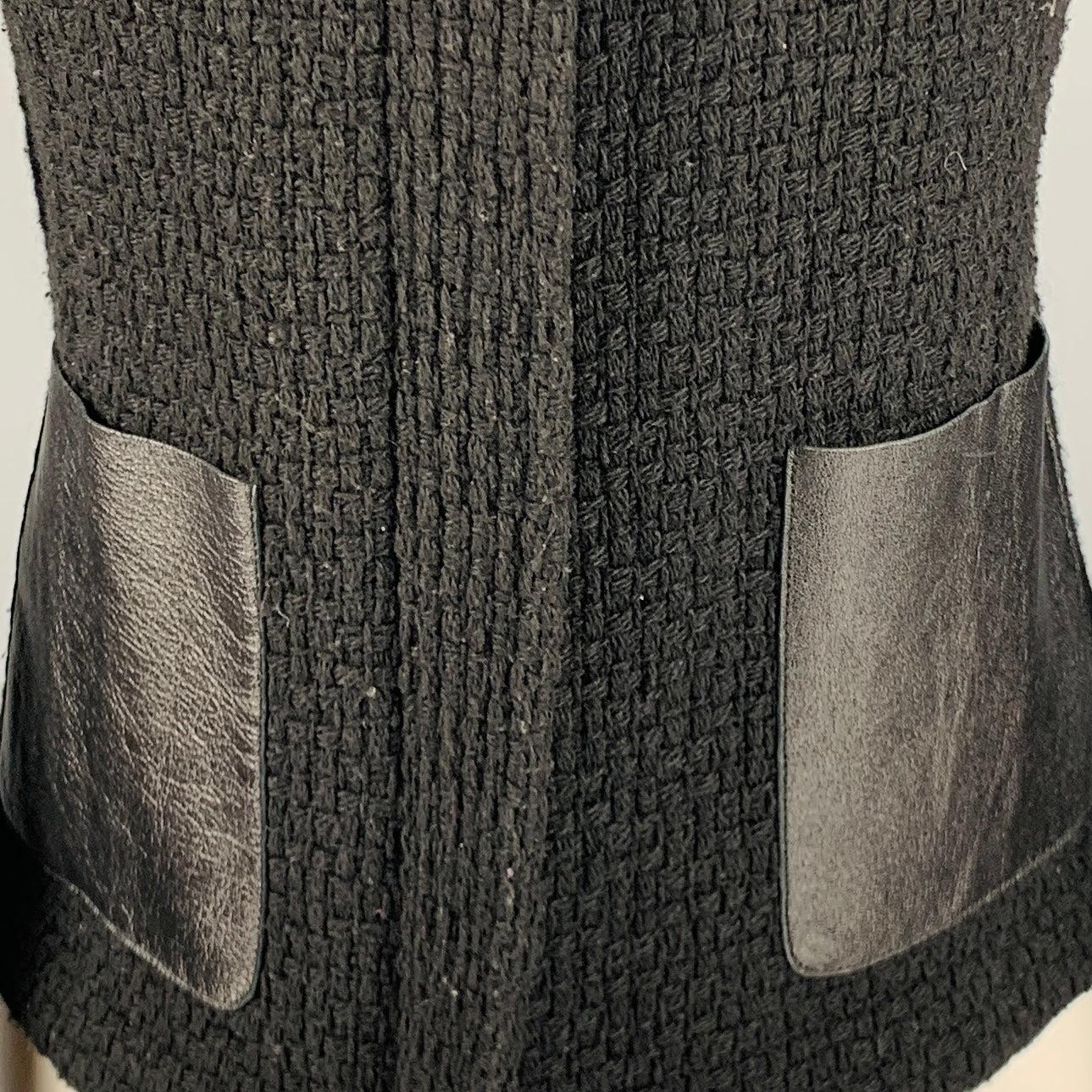 VINCE jacket
in a black woven wool blend fabric featuring two faux leather pockets, a collarless style, and zip up closure.Very Good Pre-Owned Condition. Moderate pilling. 

Marked:   6 

Measurements: 
 
Shoulder: 13.5 inches Bust: 30 inches