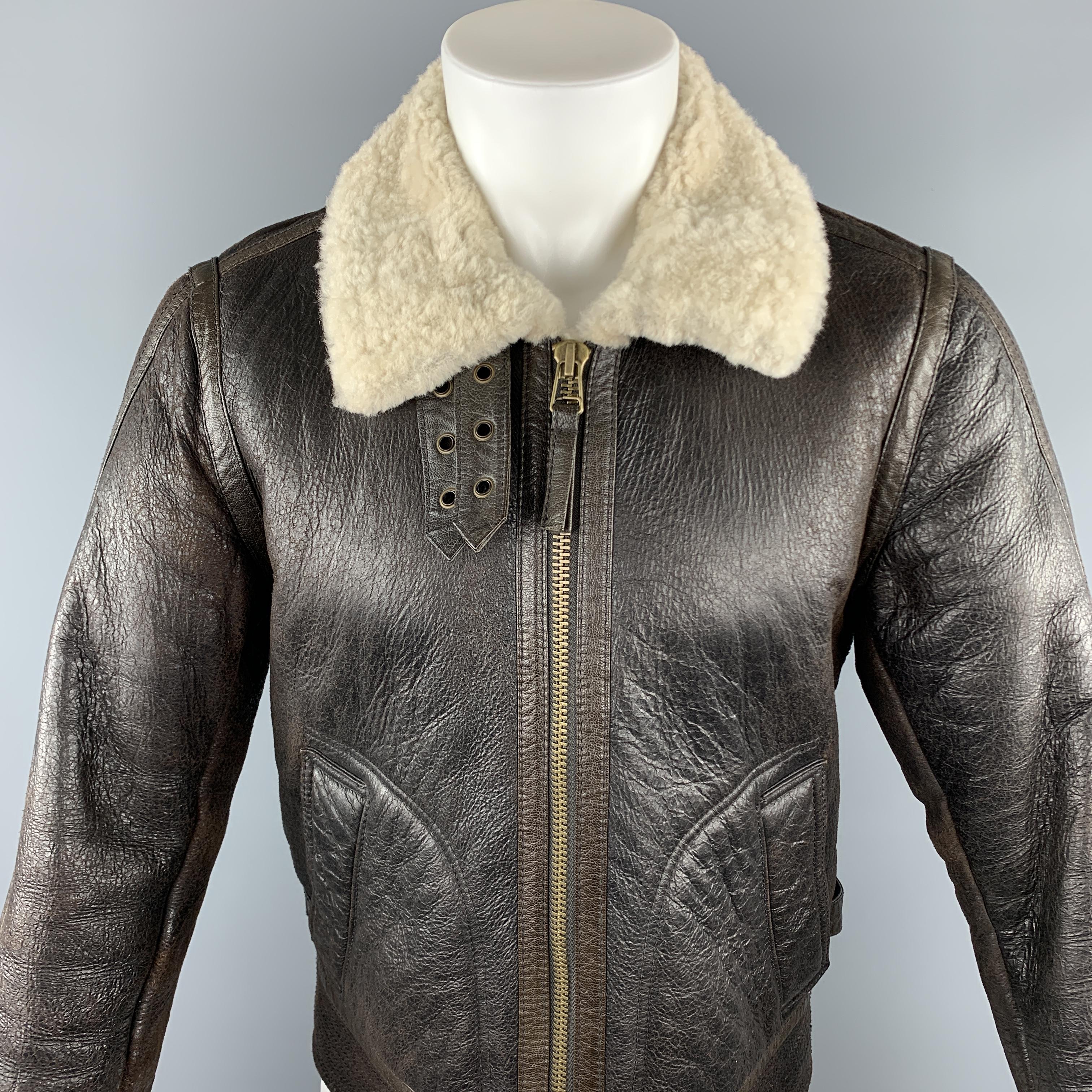 VINCE jacket comes in a brown lamb cracked shearling featuring a bomber style, belted collar, side belted details, and a full zip closure.

Very Good Pre-Owned Condition.
Marked: US M

Measurements:

Shoulder: 15.5 in.
Chest: 42 in. 
Sleeve: 26 in.