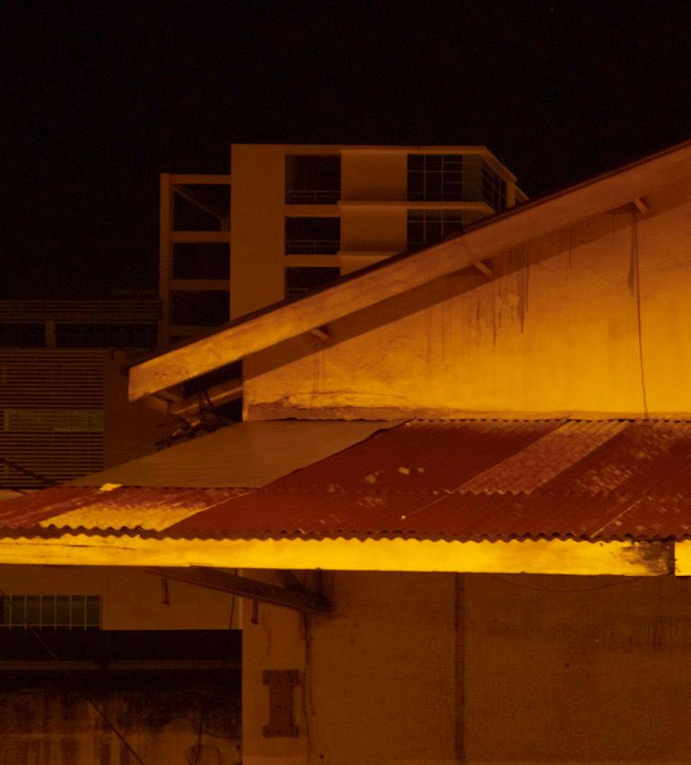Borneo 6: urban city architecture in dark night with gold tones, Southeast Asia - Photograph by Vincent Dixon