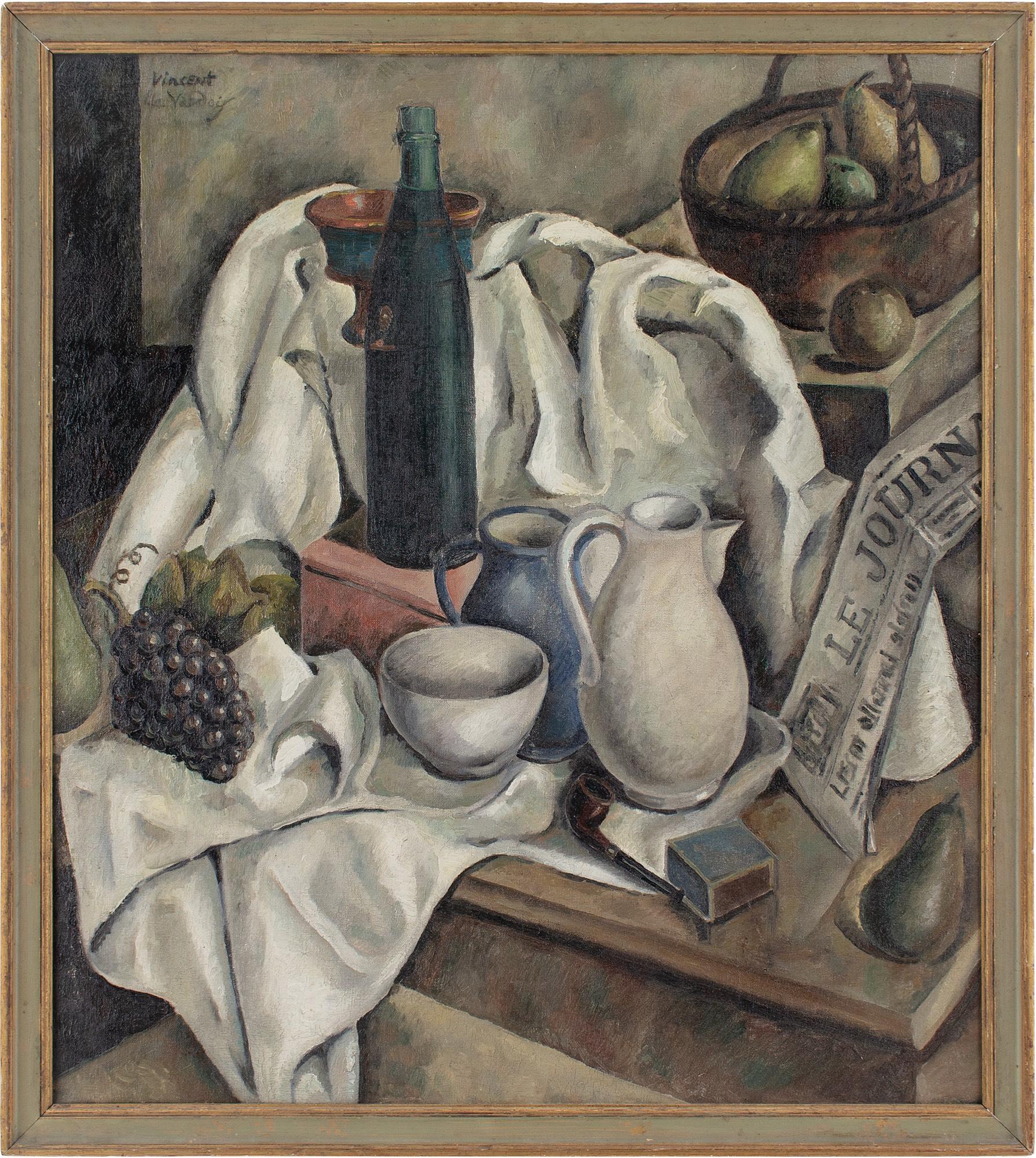 This early to mid-20th-century oil painting by ‘Vincent Le Vaudois’ depicts a still life with an assortment of objects including jugs, bottle, bowl, fruit, tablecloth, basket and newspaper. Produced around 1935, it emerged from a loosely connected