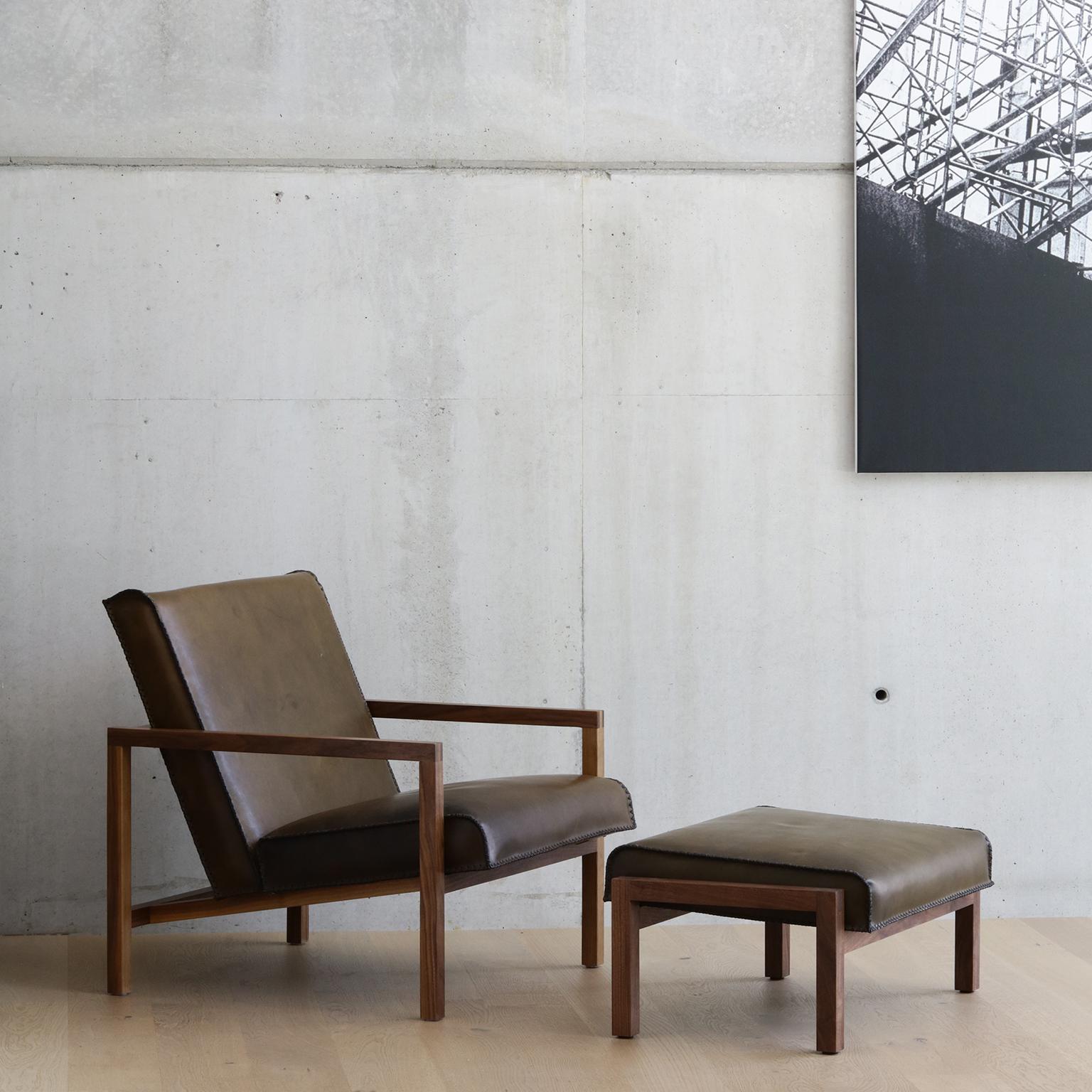 The Vincent lounge chair with matching ottoman set is finely crafted by hand. Shown here the set is displayed in olive green heritage leather on a black walnut frame. 

This Classic lounge chair profile is made unique with the use of our signature