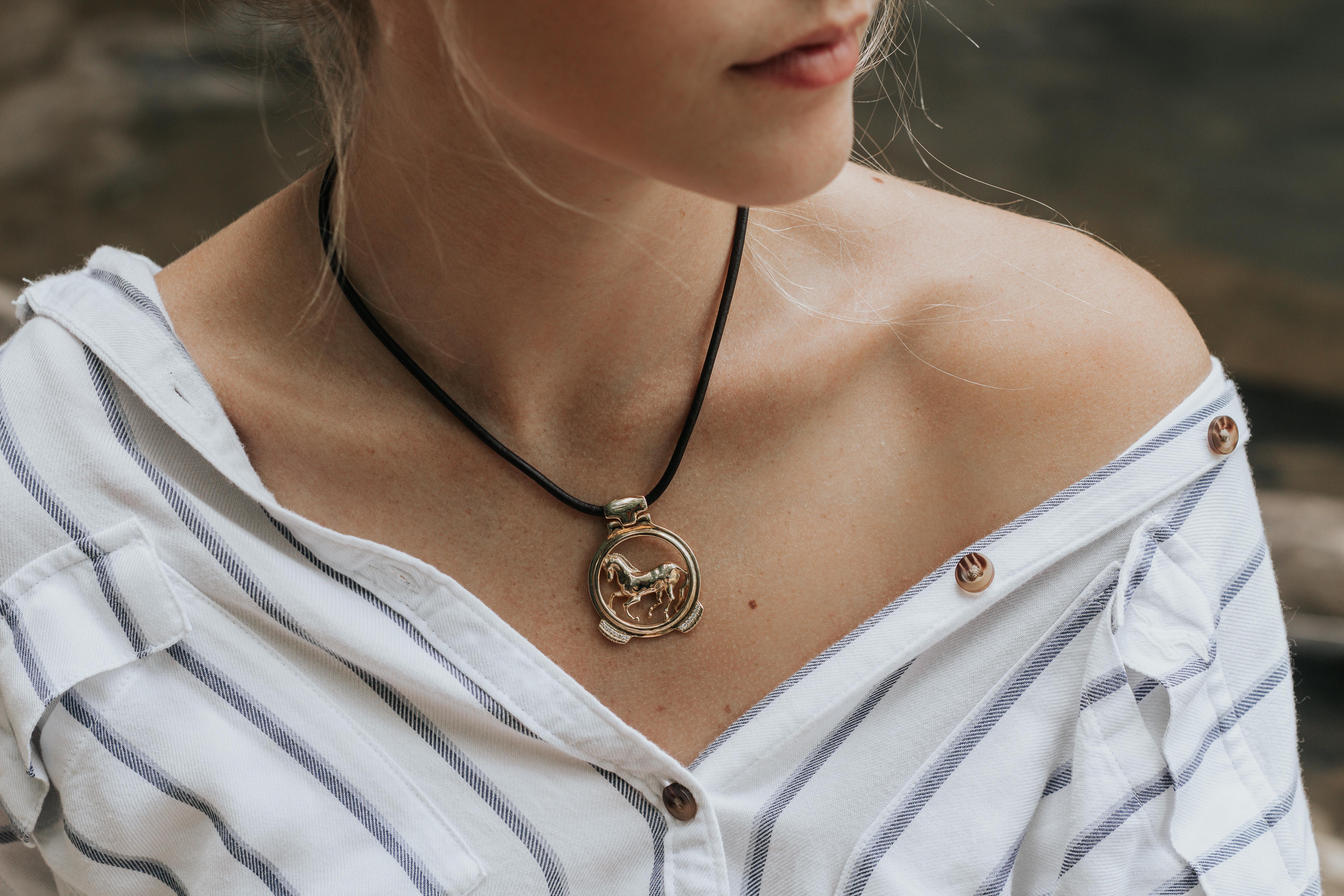 Part of the Vincent Peach Equestrian Collection, the Finnhorse Necklace has our signature 14kt Yellow Gold Horse Pendant with round White Diamonds on a Premium Leather Cord with a Luxurious Tahitian Pearl Clasp. This necklace comes in the Standard