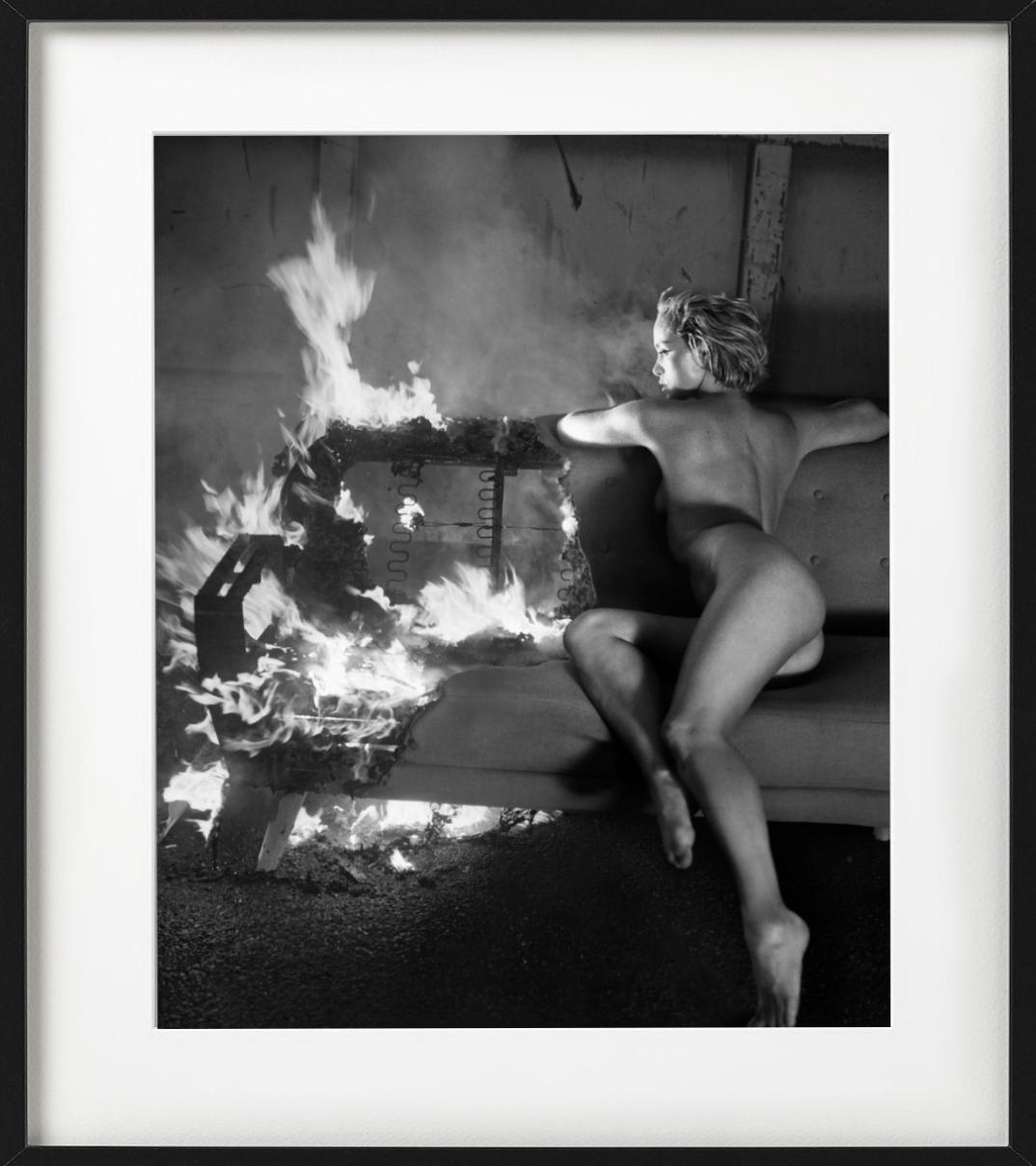 Victoria Fire for Playboy i- b&w photograph nude model sitting on a burning sofa - Photograph by Vincent Peters