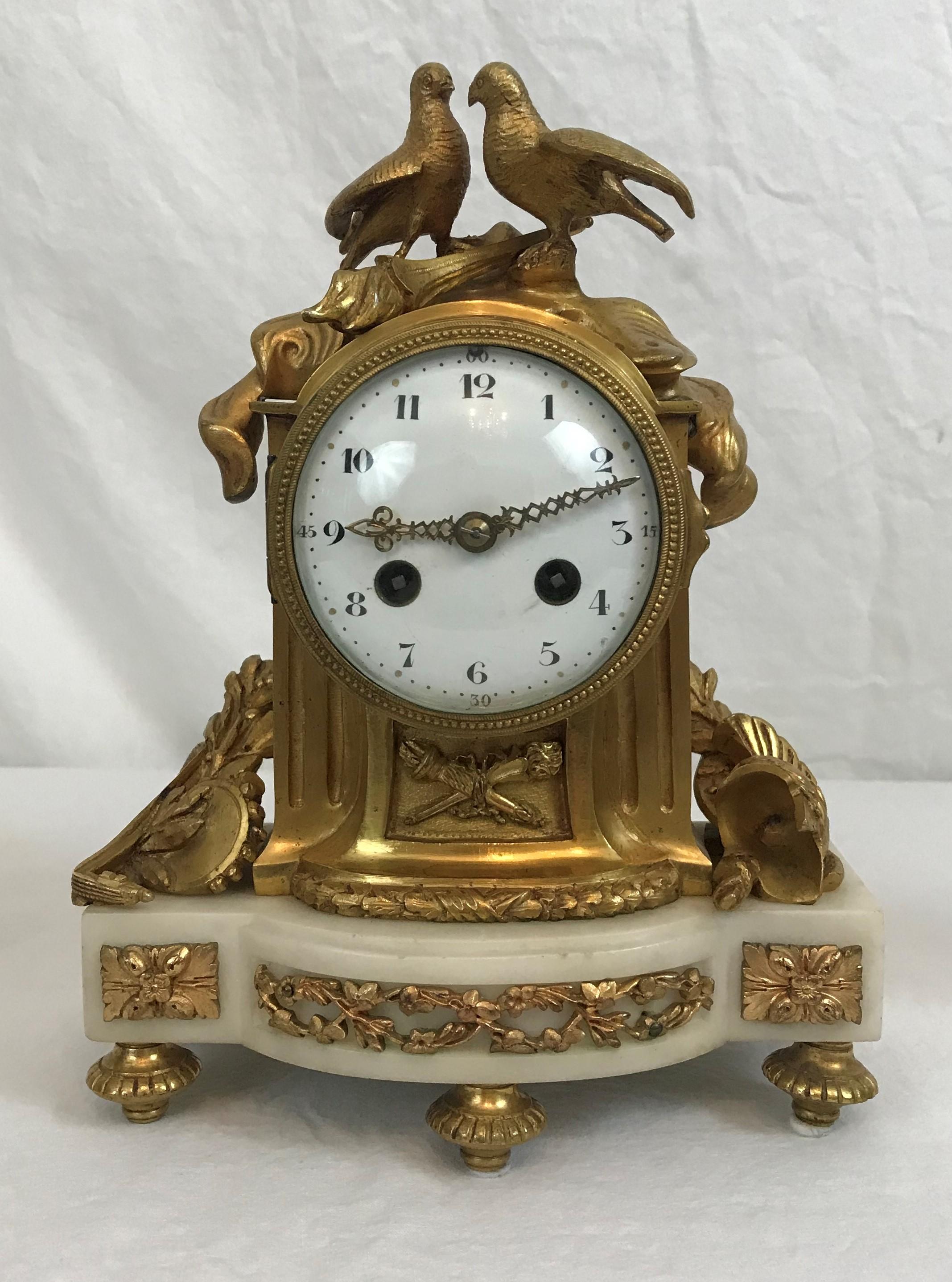Small size clock and candelabra garniture set. French white marble and ormolu, circa 1890-1900.

Clock is in running condition. Photographed inside without pendulum, but original pendulum is included. 10-1/2