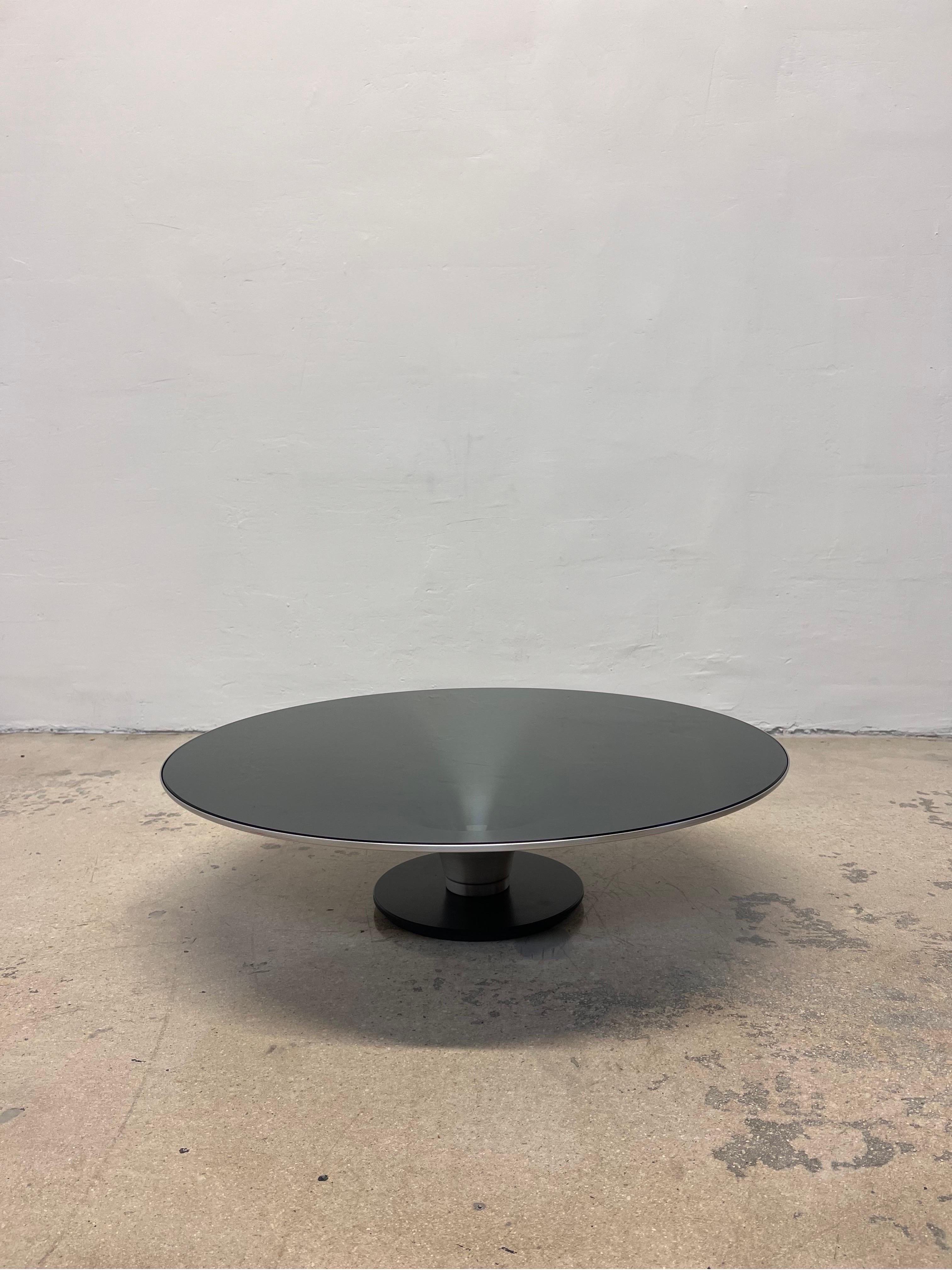 Roche Bobois low OVNI ø.70 cocktail table designed by Vincenzo Maiolino. The steel base has a black matte finish while the aluminum cone table structure is natural with a clear coat varnish to protect the finish. The smoked glass is 6mm thick,