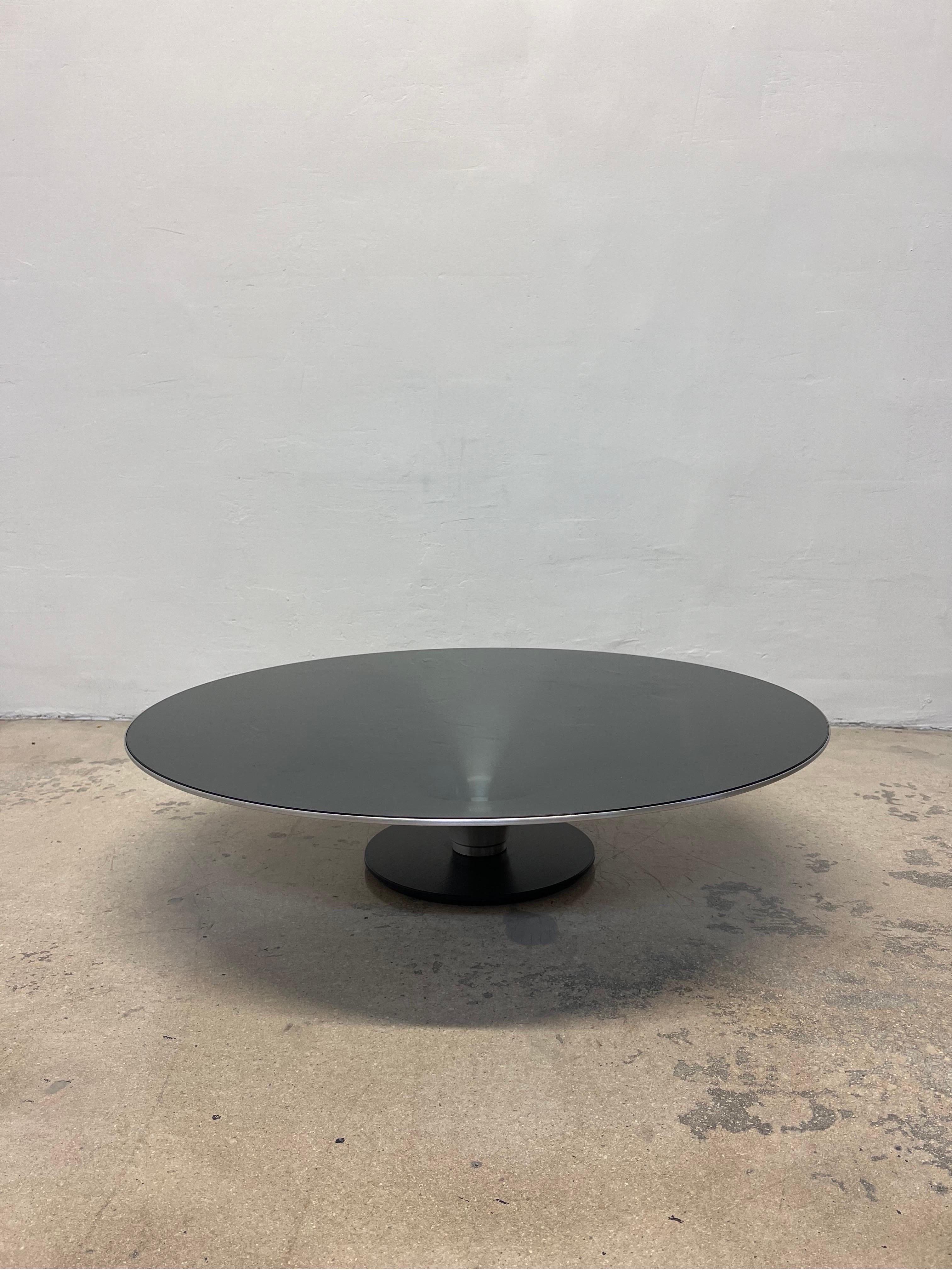 Roche Bobois low OVNI ø.90 cocktail table designed by Vincenzo Maiolino. The steel base has a black matte finish while the aluminum cone table structure is natural with a clear coat varnish to protect the finish. The smoked glass is 6mm thick,