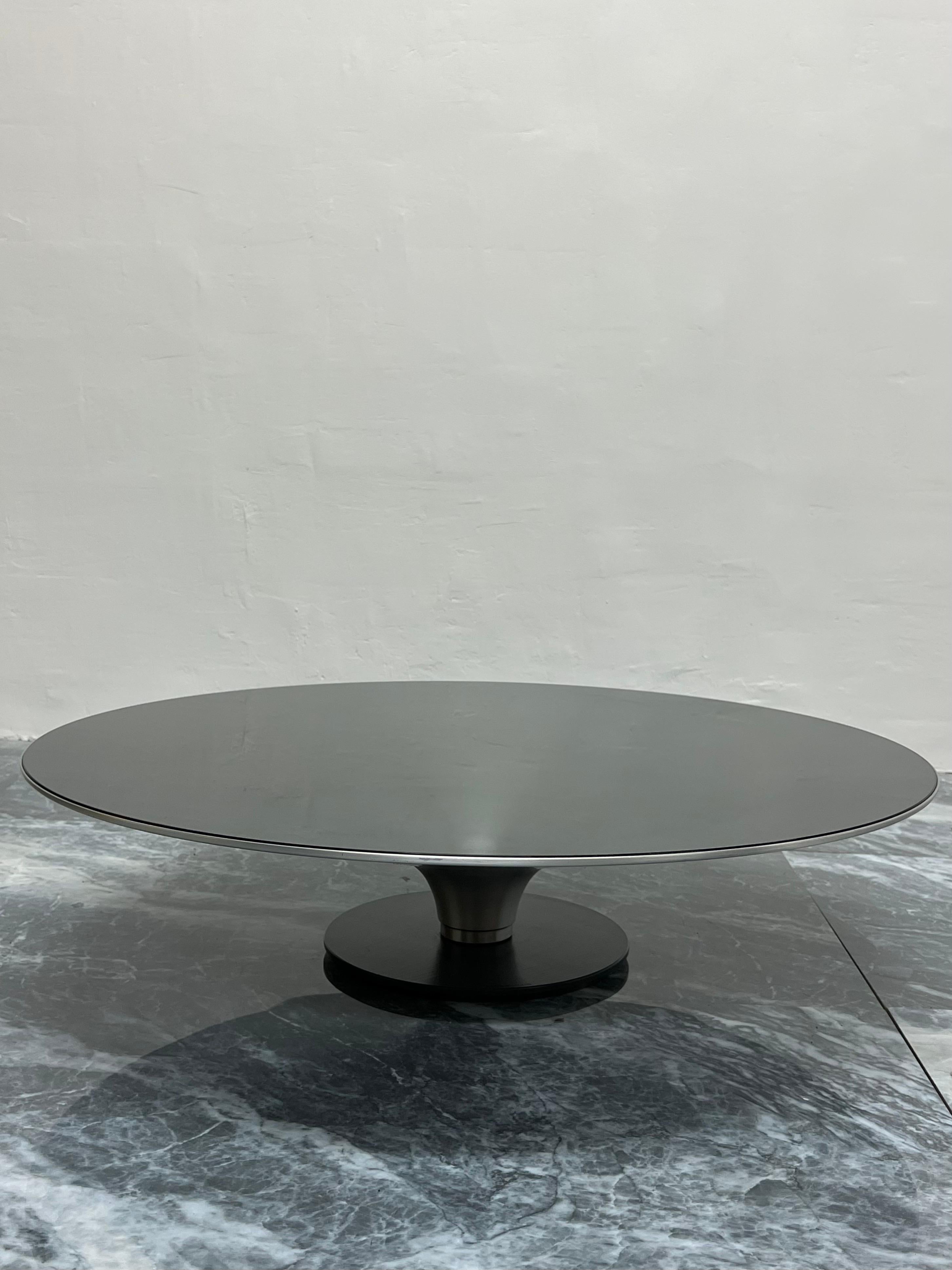 Roche Bobois low OVNI cocktail table designed by Vincenzo Maiolino. The steel base has a black matte finish while the aluminum cone table structure is natural with a clear coat varnish to protect the finish. The glass is 6mm thick and