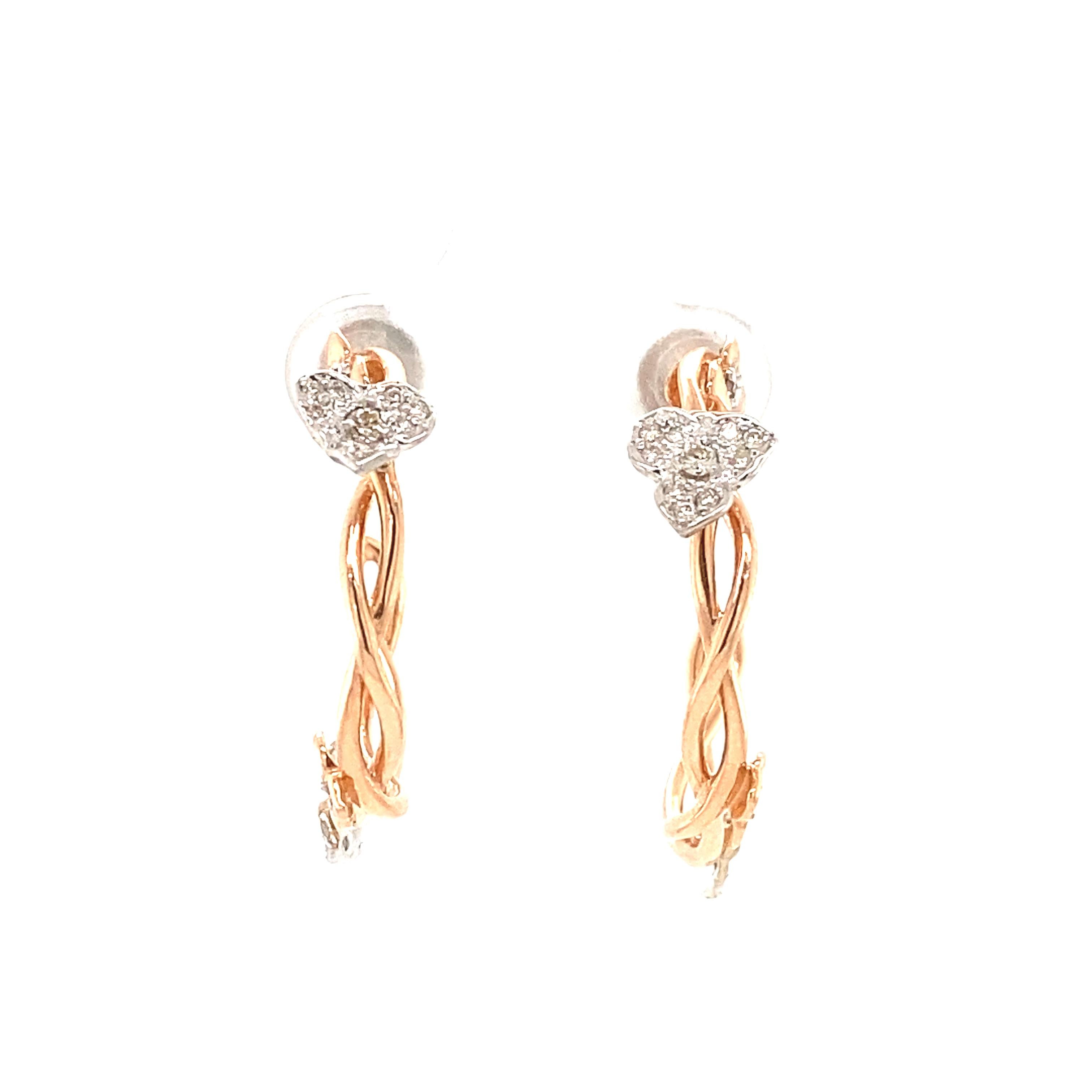 A pair of rose gold hoop earrings, each featuring a twisted design that adds a dynamic and elegant look. At the front of each hoop is a floral-shaped motif encrusted with multiple small, diamonds that catch the light. This jewelry is a sophisticated